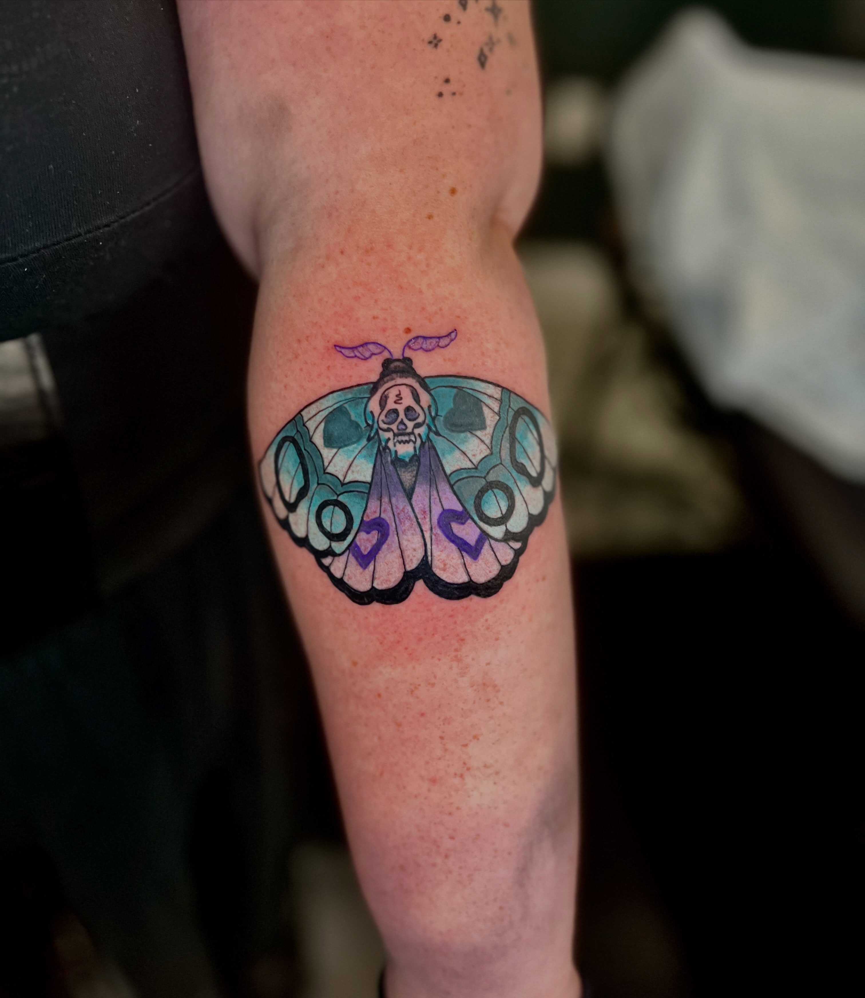 Butterfly with skull watercolor tattoo on the forearm by Mason McCubbin