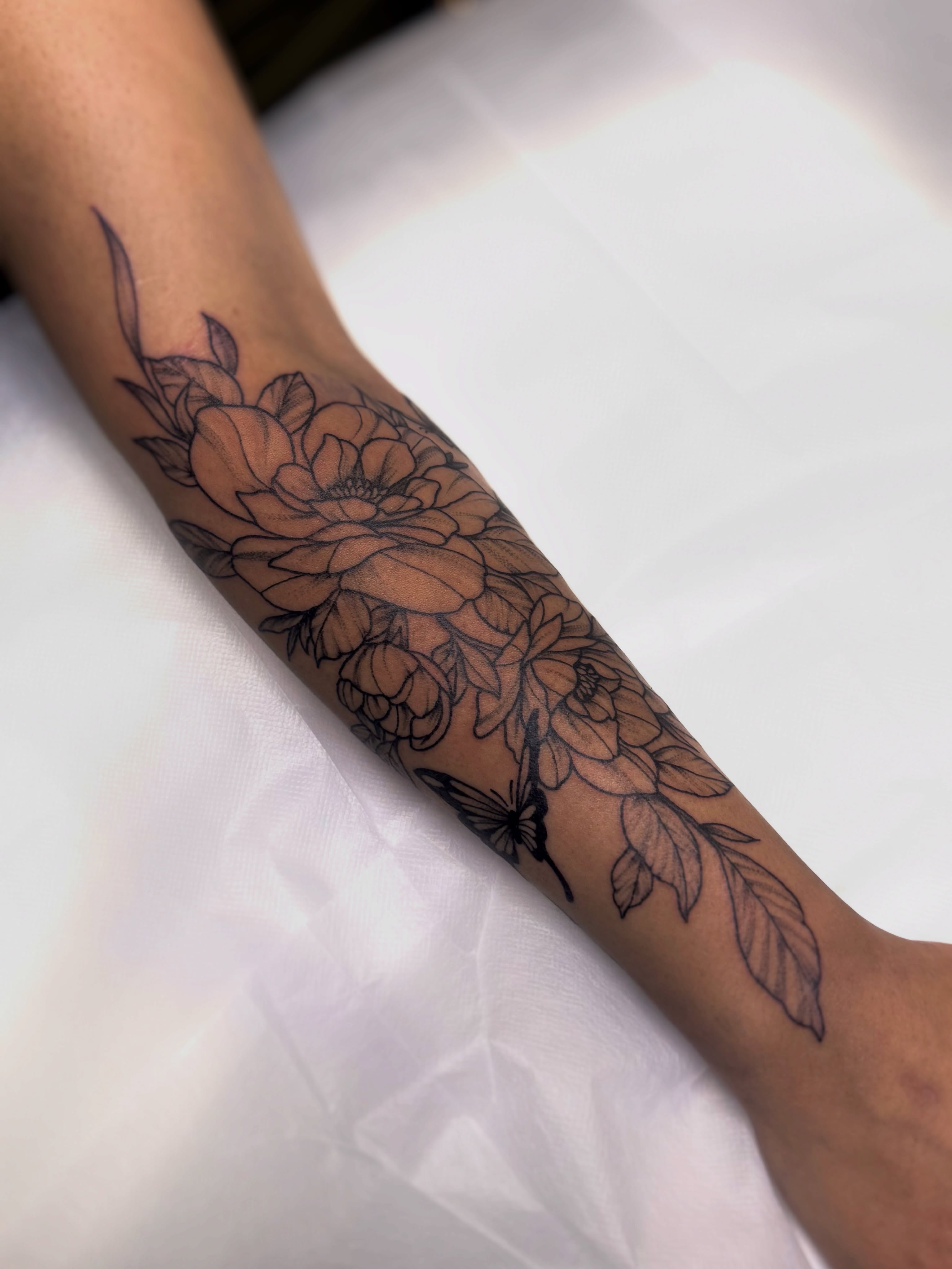 Floral bouquet black and grey tattoo on the forearm by Kyndall Lynn, Waxahachie, Texas