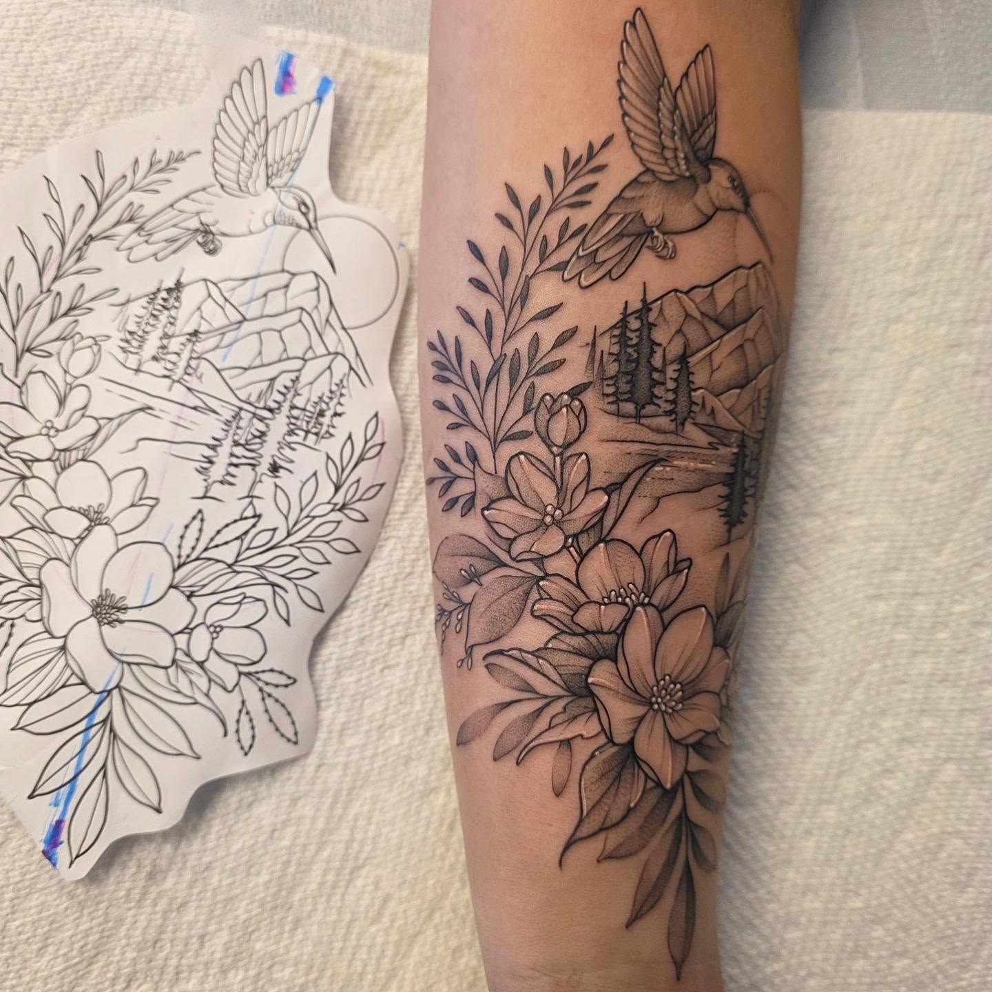 Hummingbird and flowers black and grey tattoo on the forearm by Dani Bond