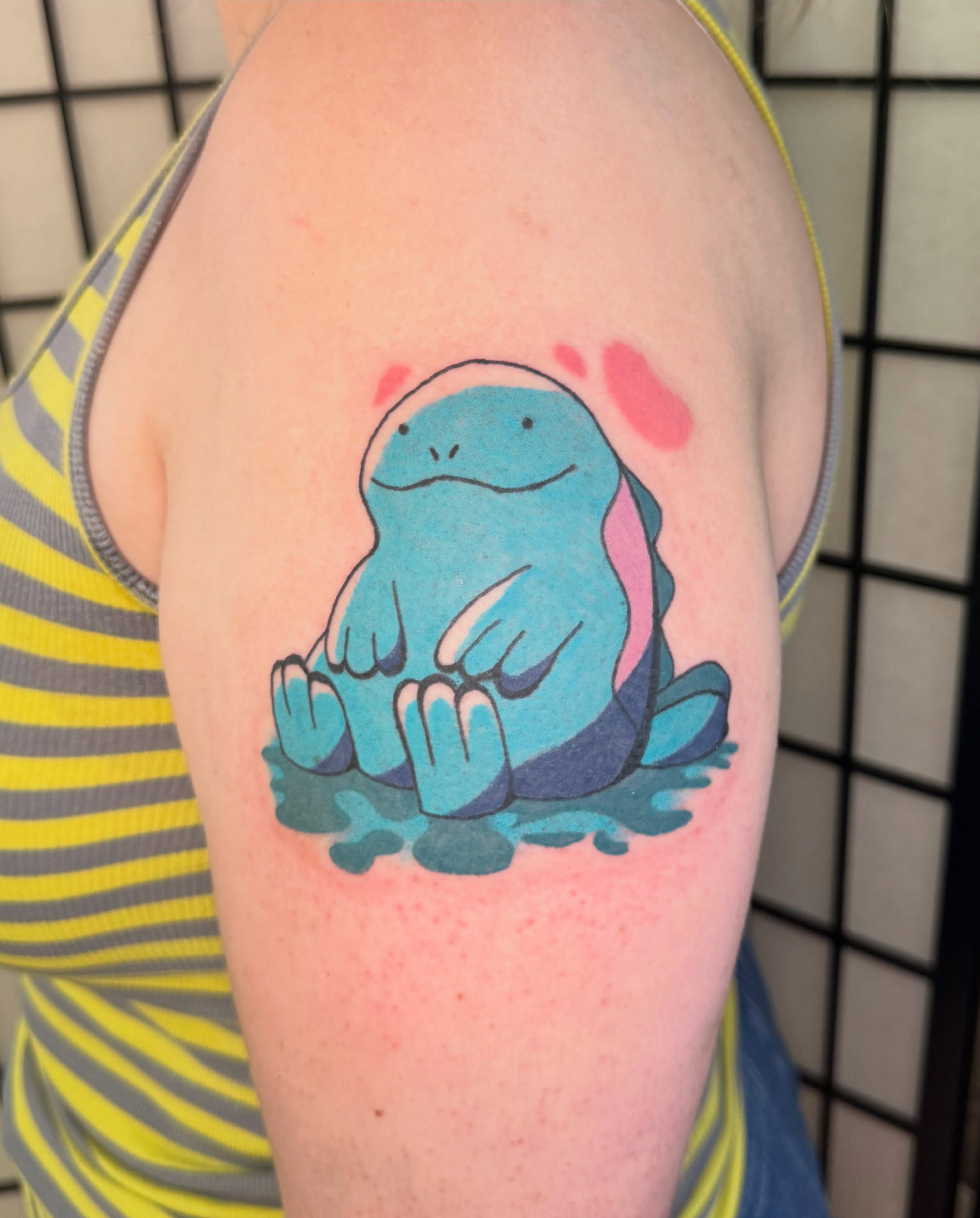 Squishy blue creature illustrative tattoo on the upper arm by Zac Smith-Chevalier