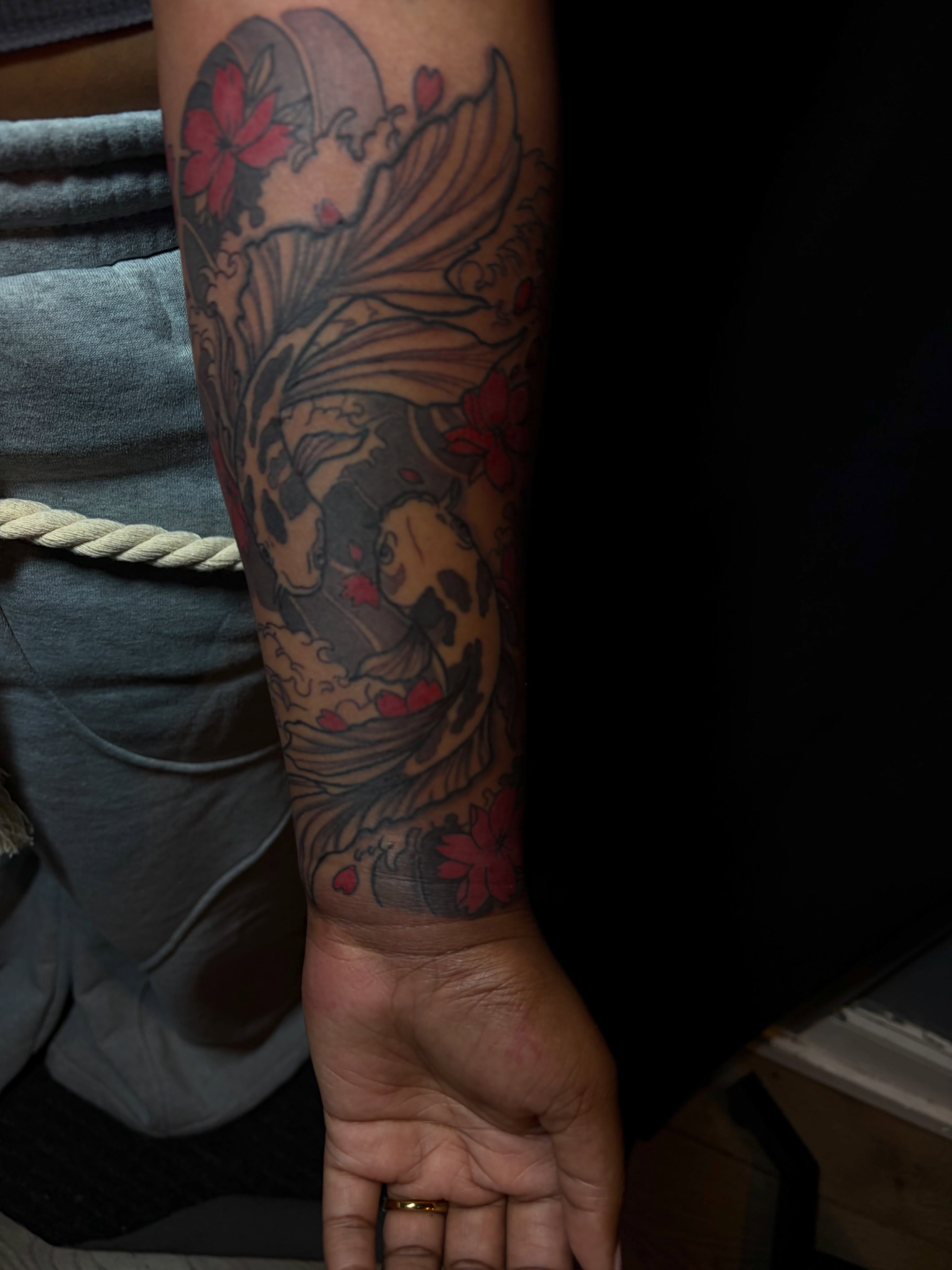 Koi fish and flowers American traditional tattoo on the forearm by SpicyMvstardInkk