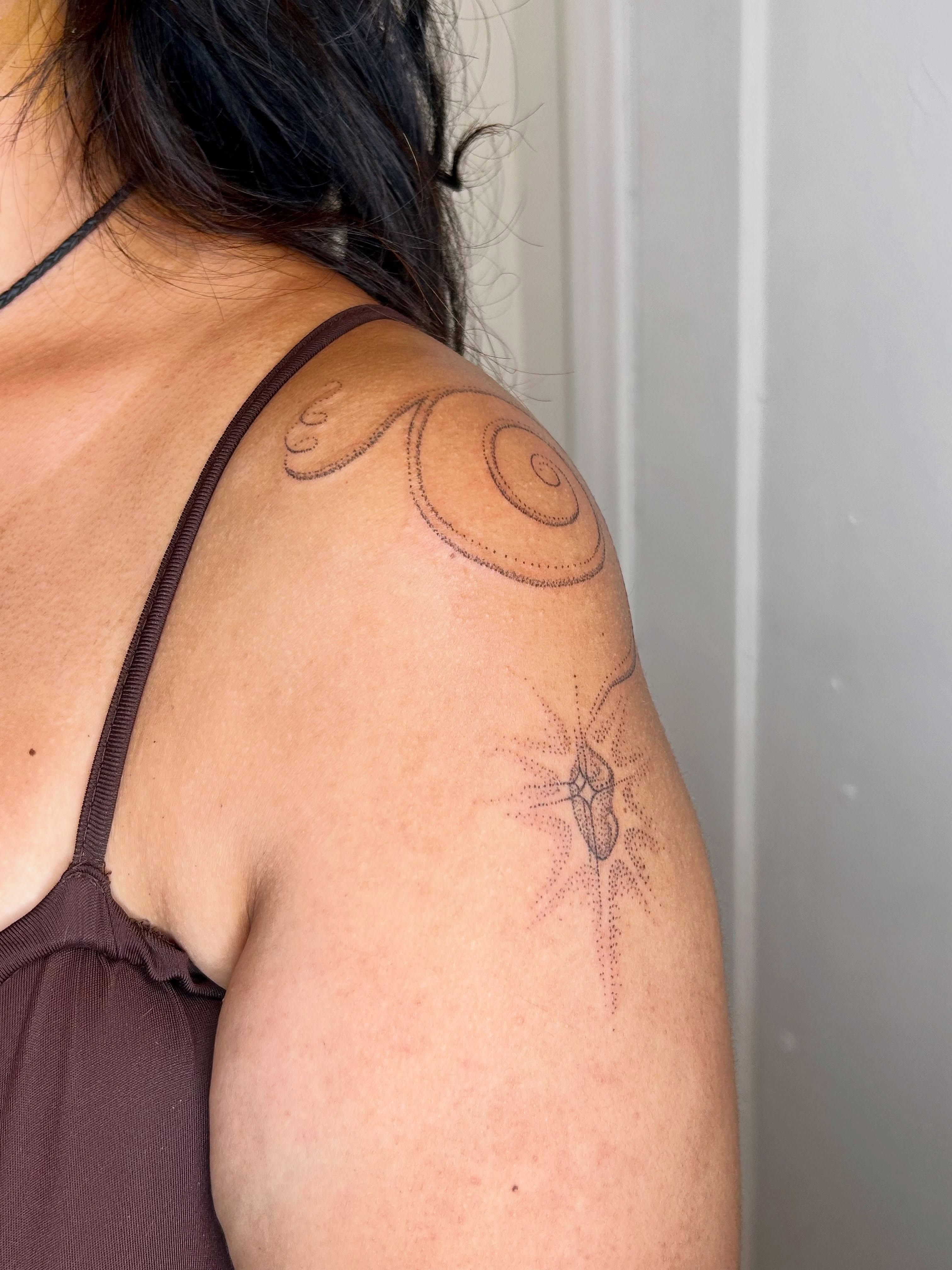Swirls and starburst dotwork tattoo on the shoulder by Nicolette