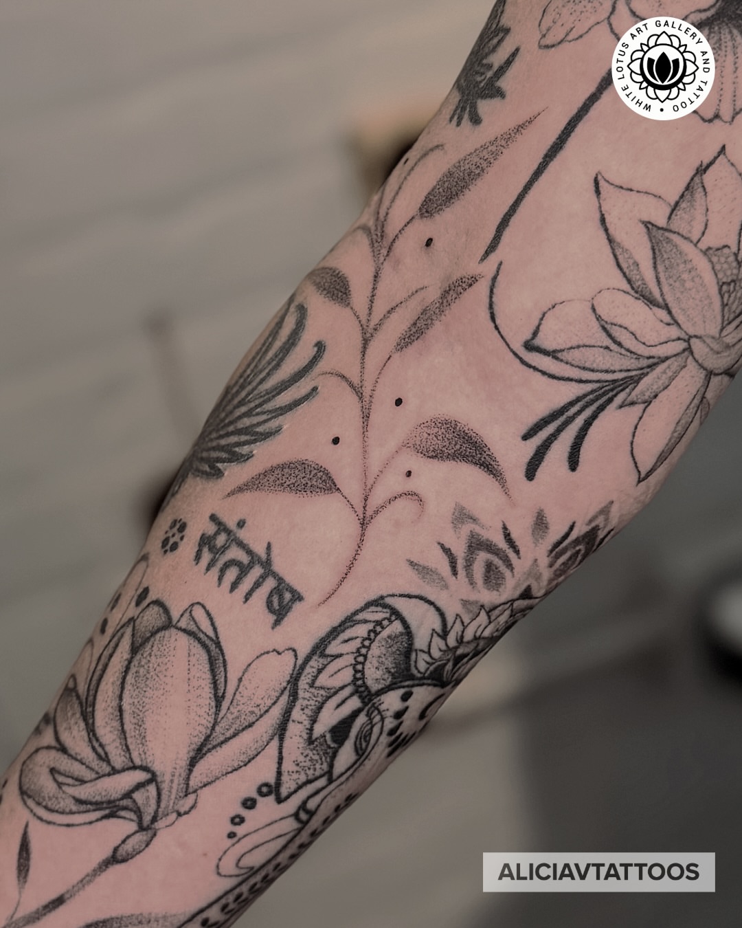Lotus flowers and script dotwork tattoo on the forearm by Alicia Vasquez