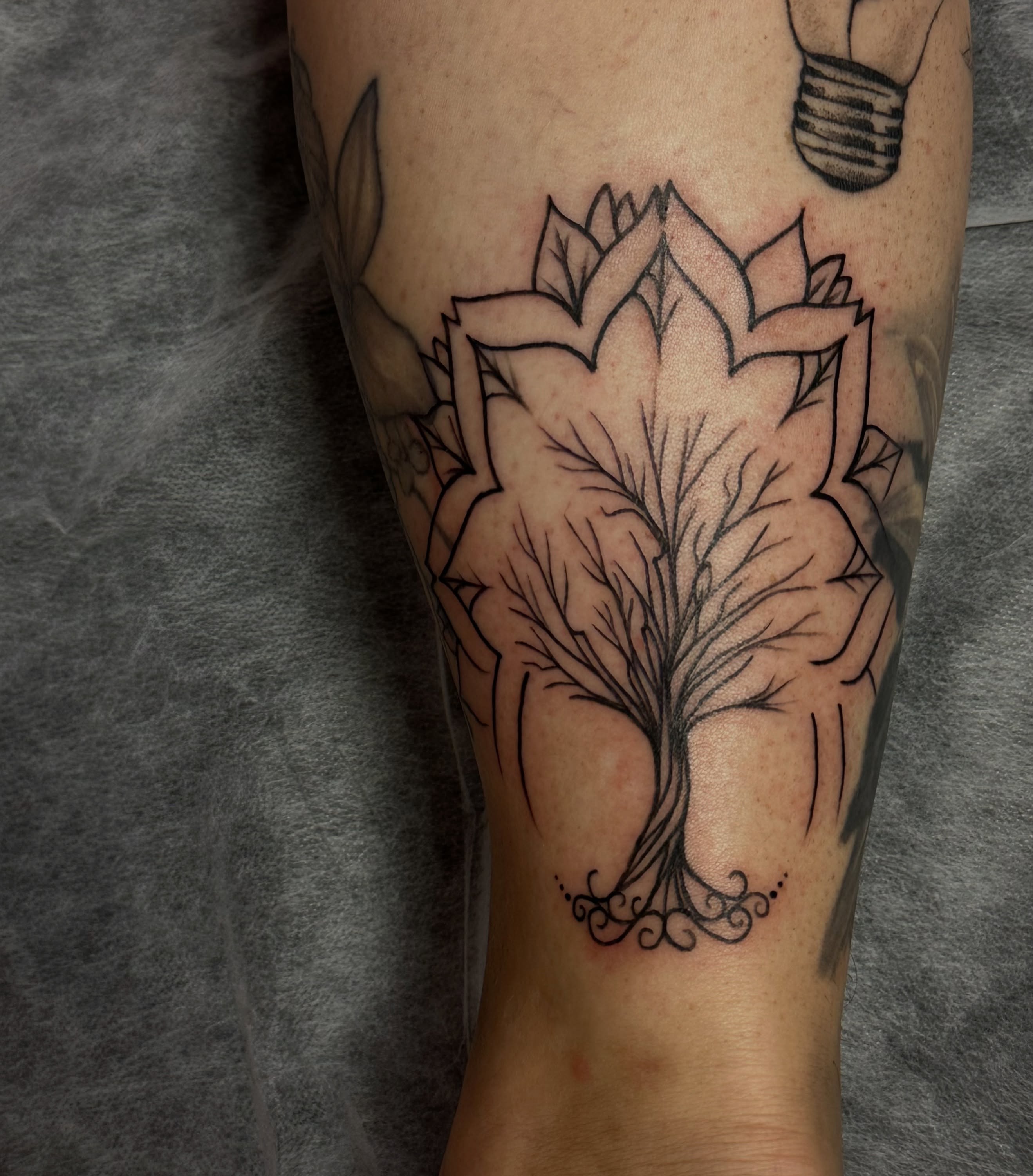 Lotus flower black and grey tattoo on the forearm by Jocelyn
