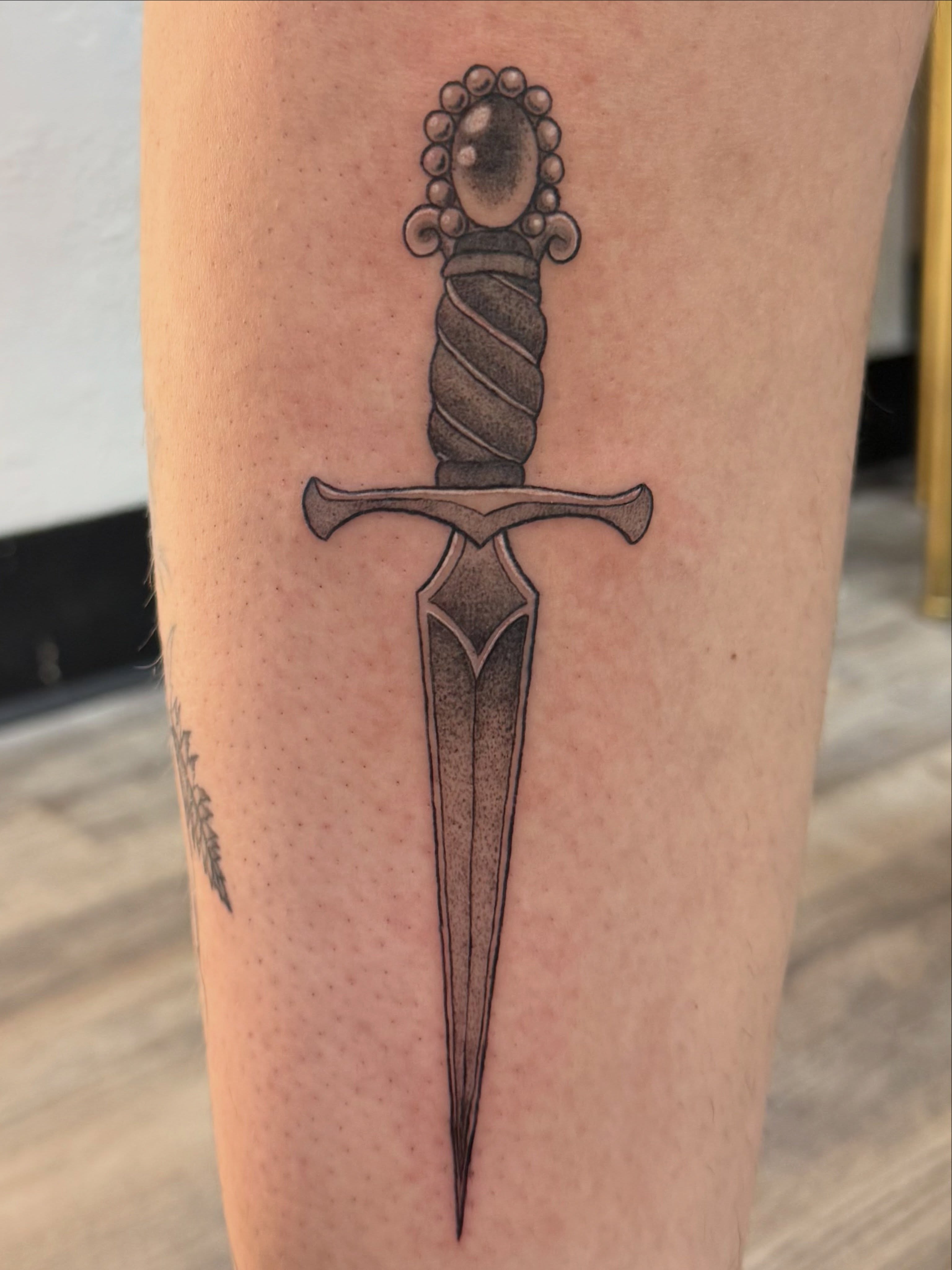 Sword black and grey tattoo on the forearm by Kate Marie