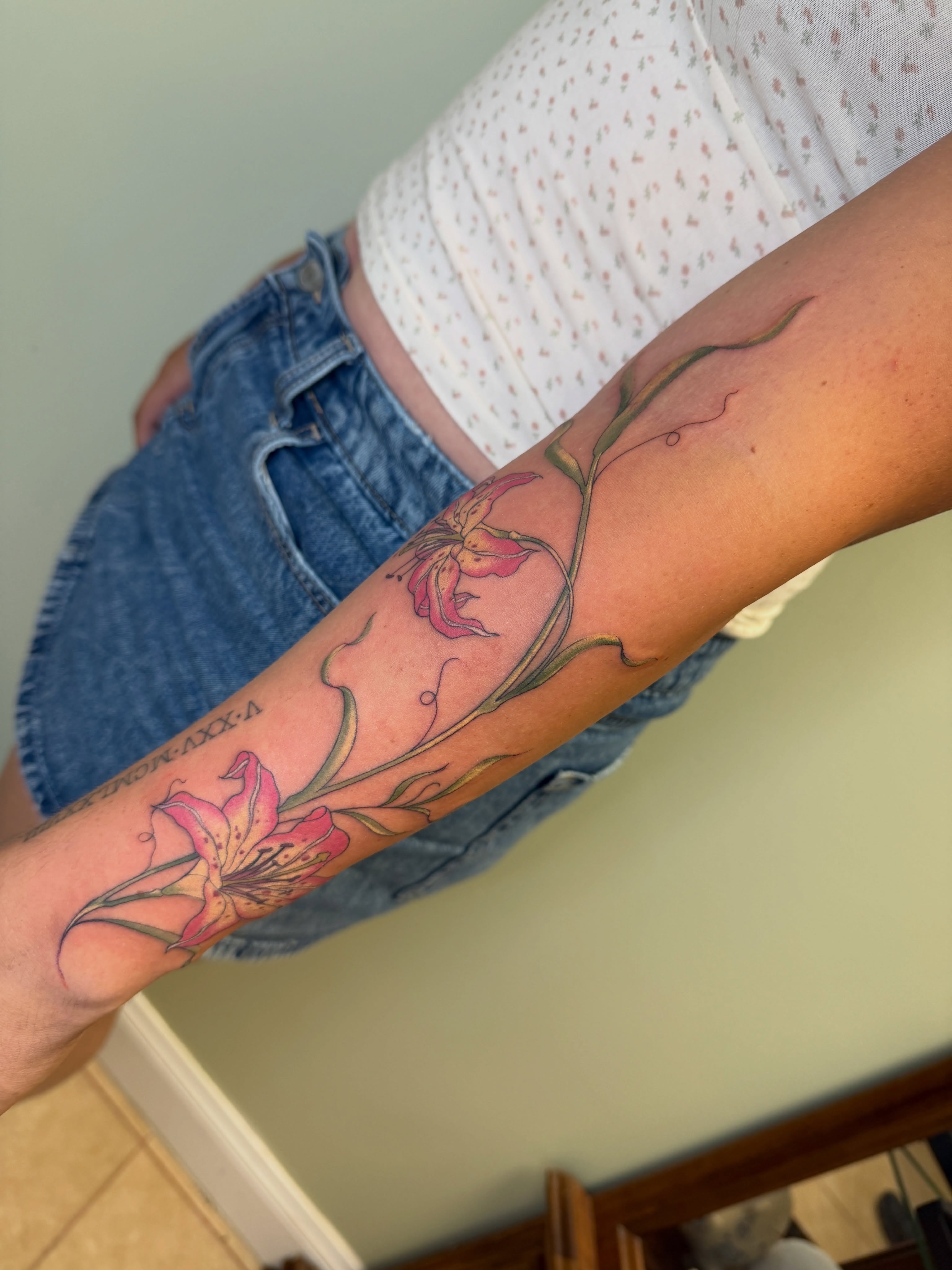 Lily flowers realism tattoo on the forearm by Koryn Donnelly