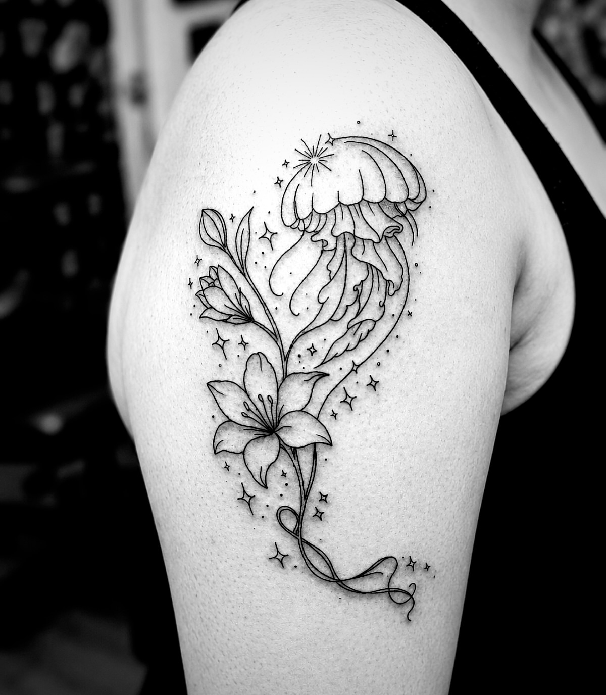 Jellyfish and lily fine line tattoo on the shoulder by Kraken ink Tattoo, San Francisco, California
