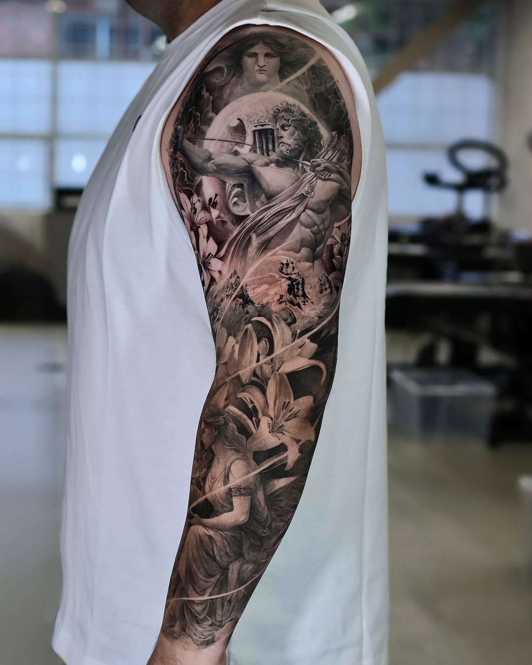 Mythological scene with figures and lilies realism tattoo on the forearm by Reset tattoo