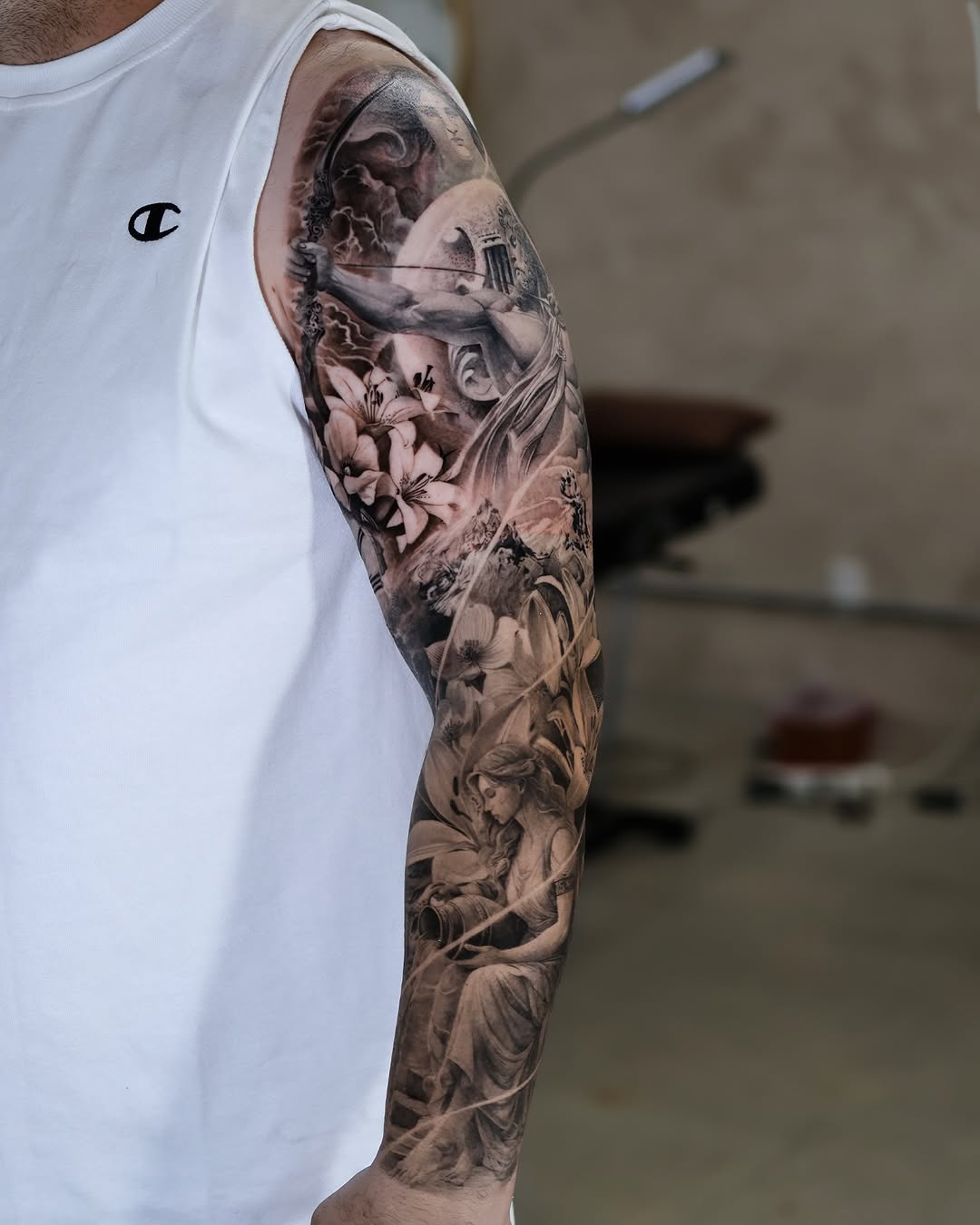 Mythological scene with figure and flowers realism tattoo on the forearm by Reset tattoo