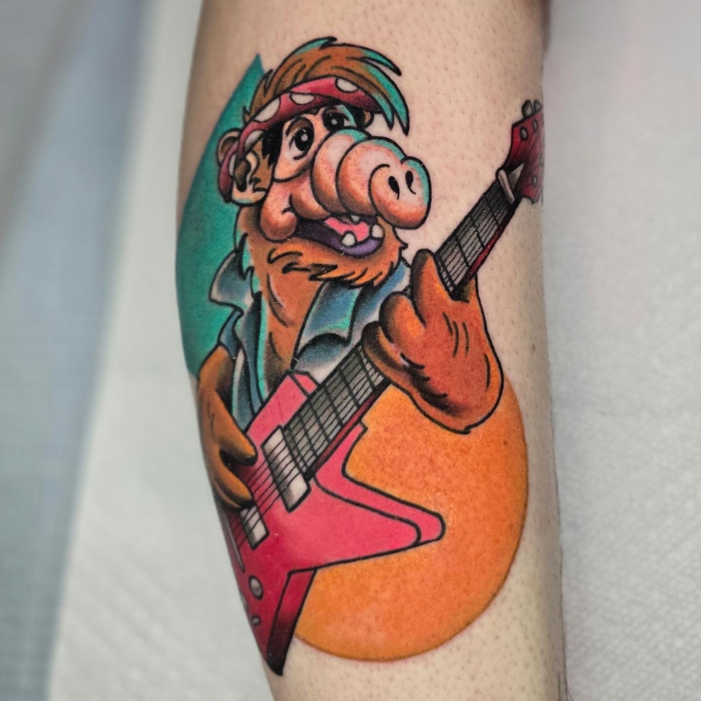 Pig playing guitar American traditional tattoo on the forearm by Adison Essig