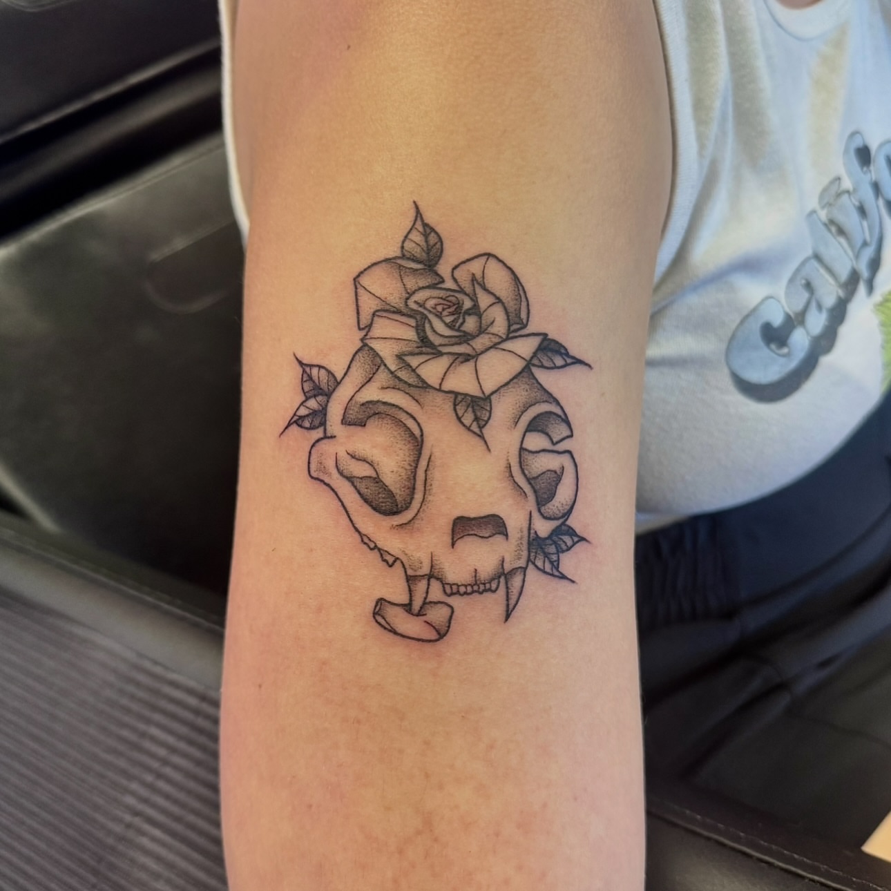 Skull with rose black and grey tattoo on the forearm by Kat Bennett
