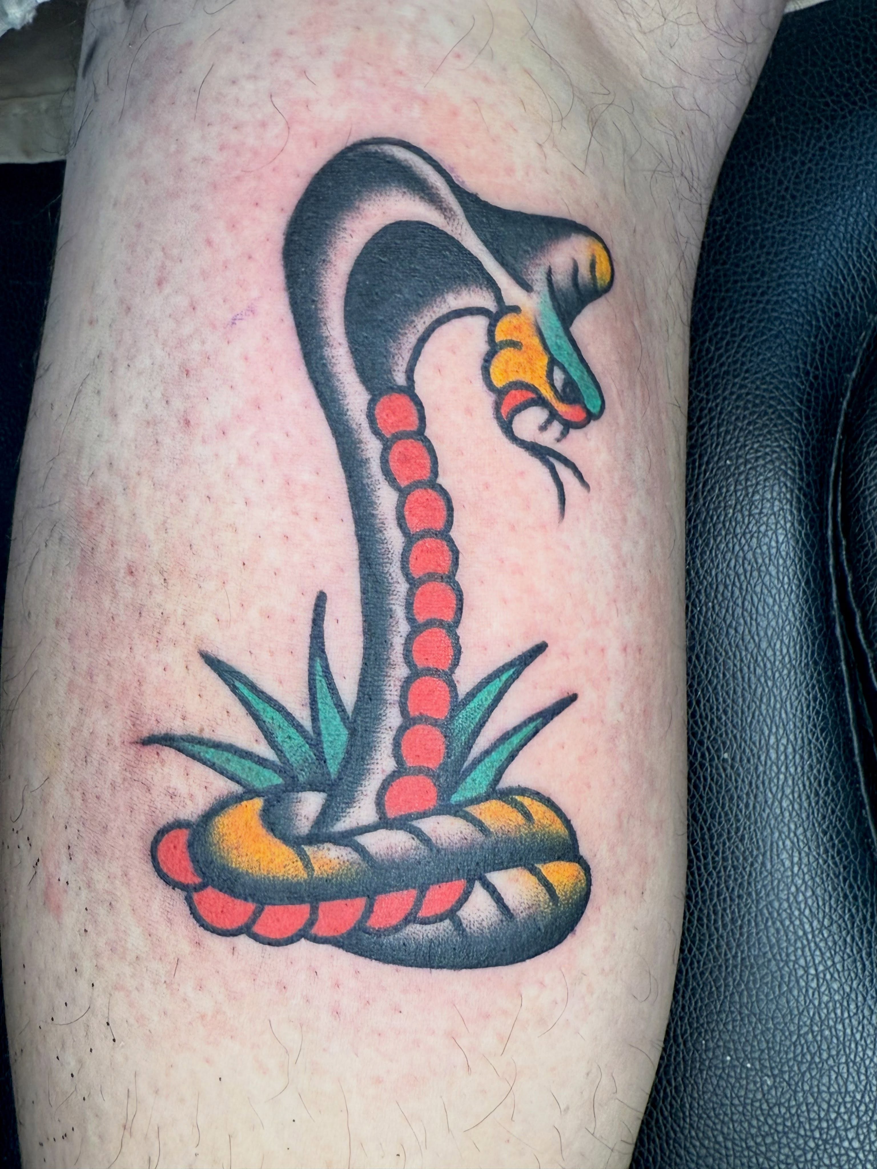 Snake American traditional tattoo on the forearm by Jesse Coldiron