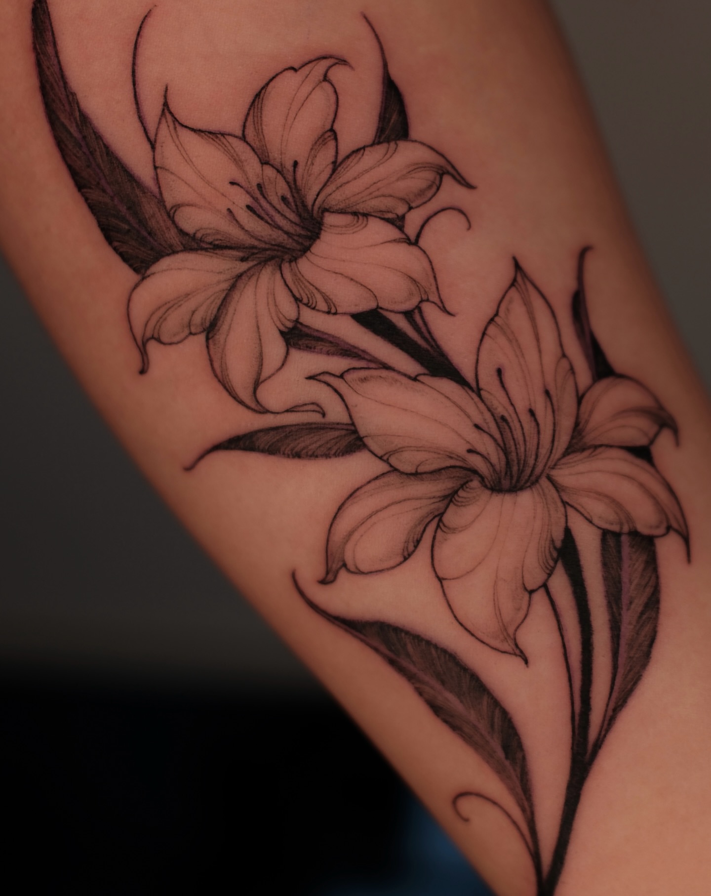 Lilies black and grey tattoo on the forearm by Sab