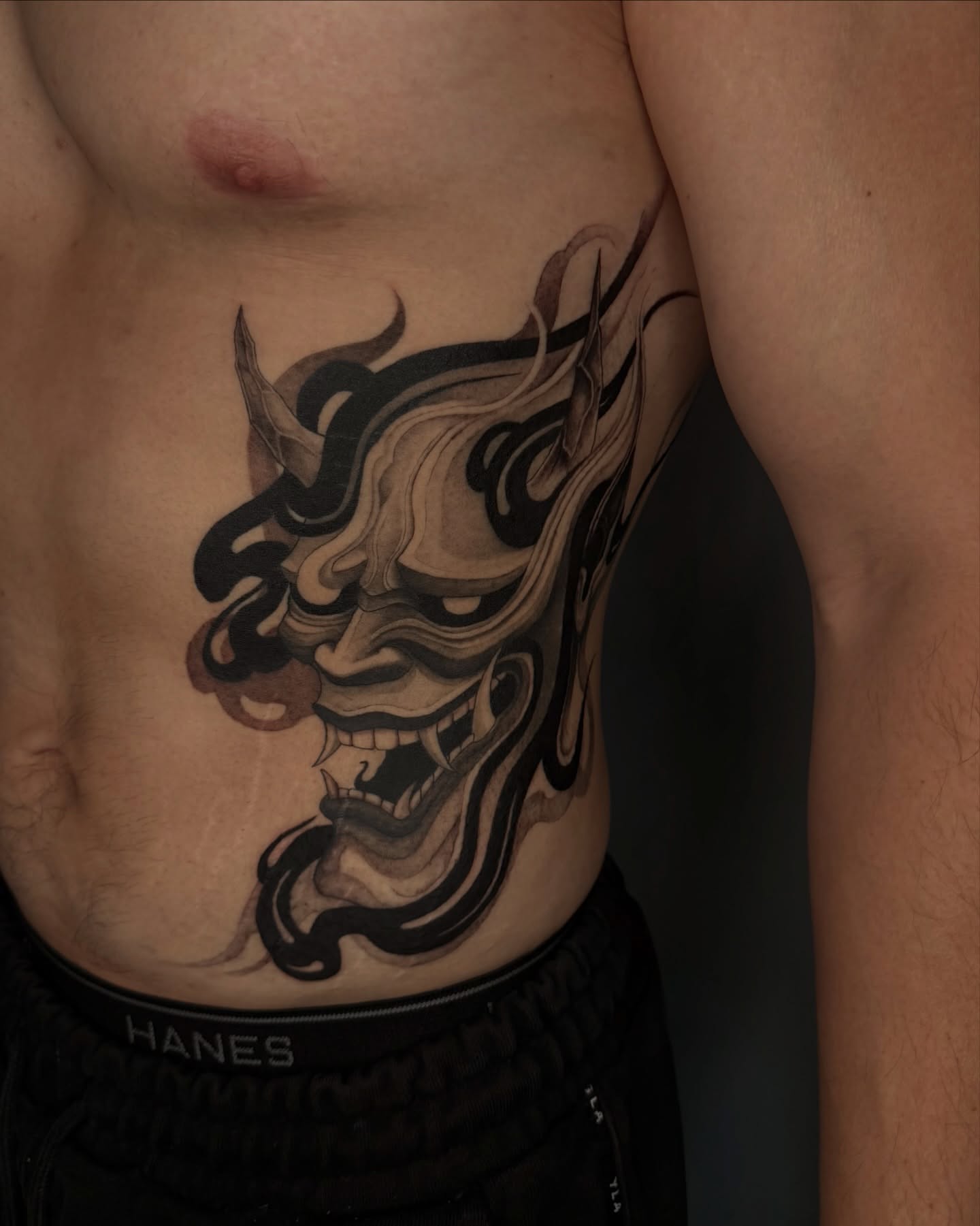 Demon mask black and grey tattoo on the chest by Sab