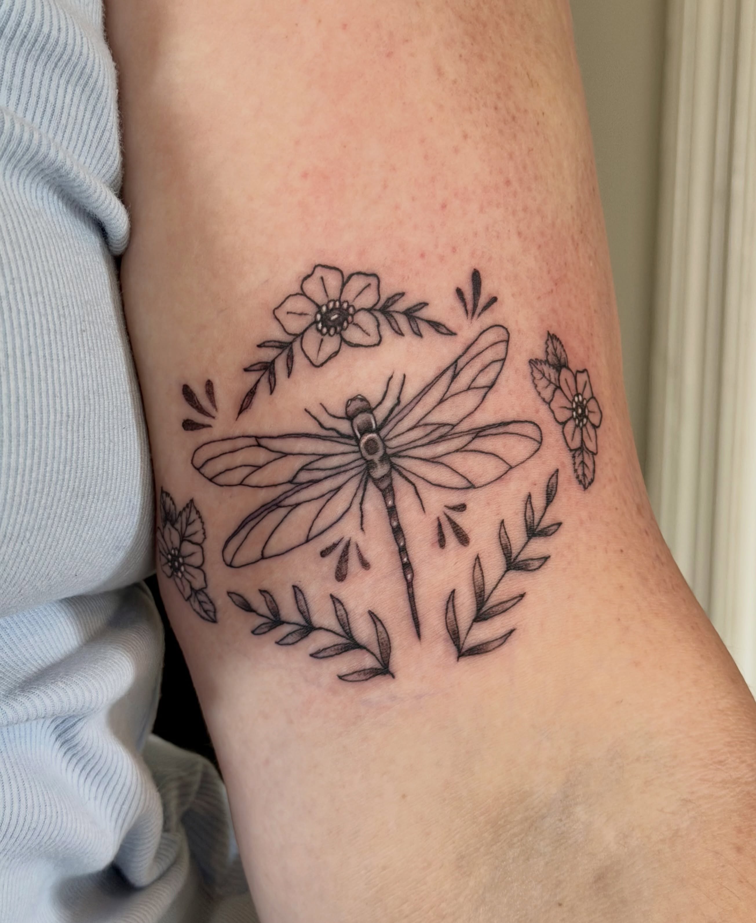 Dragonfly and flowers black and grey tattoo on the forearm by Sophia, New Carlisle, Ohio