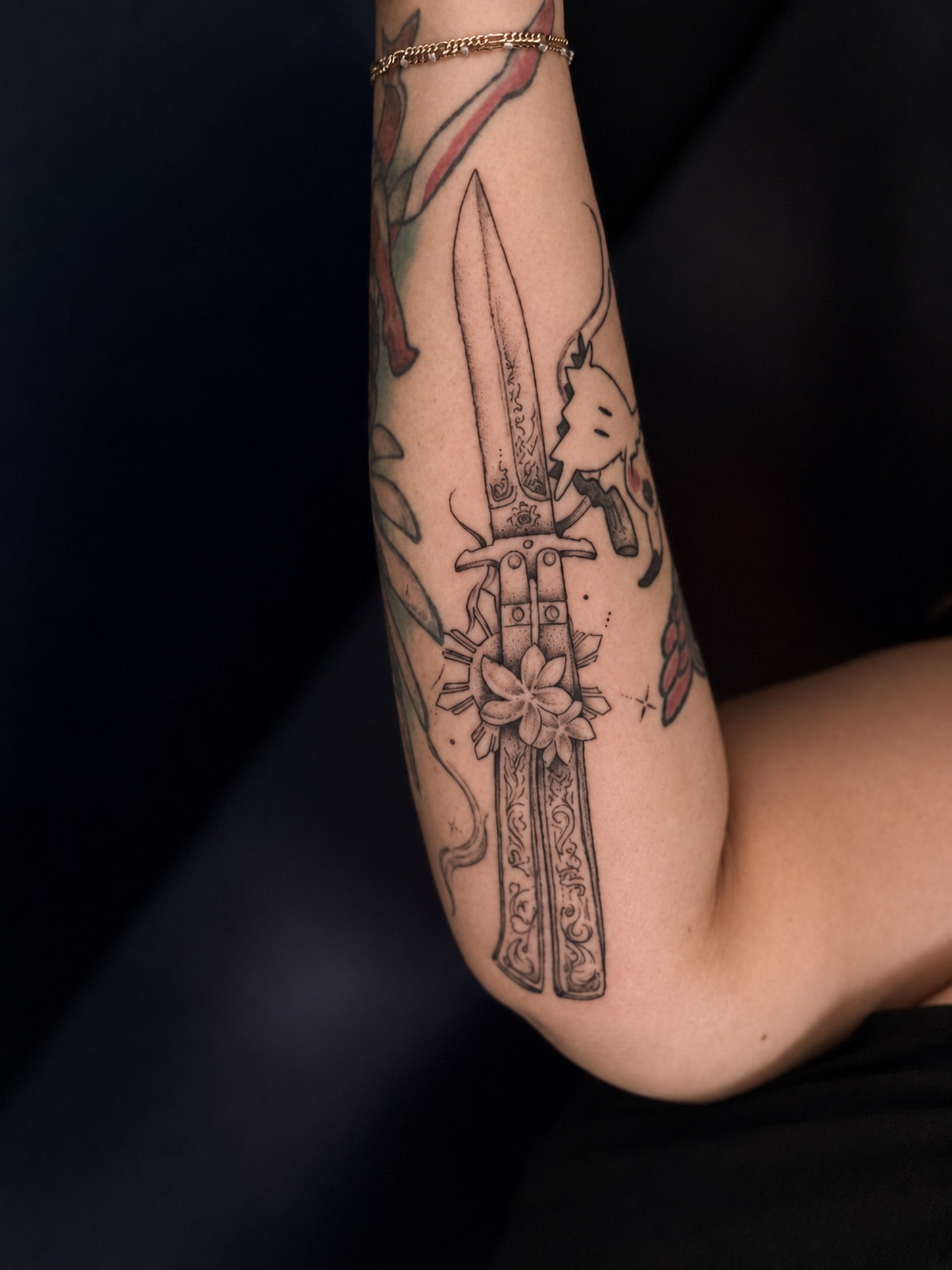 Sword and flower black and grey tattoo on the forearm by Jennifer Ramirez