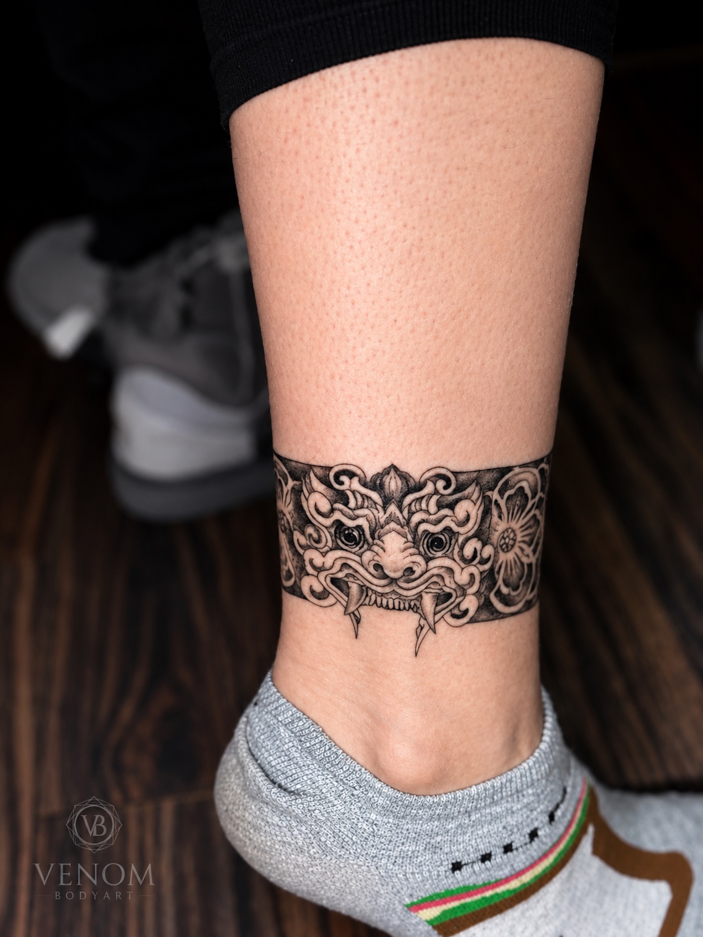 Mask black and grey tattoo on the calf by Jennifer Ramirez