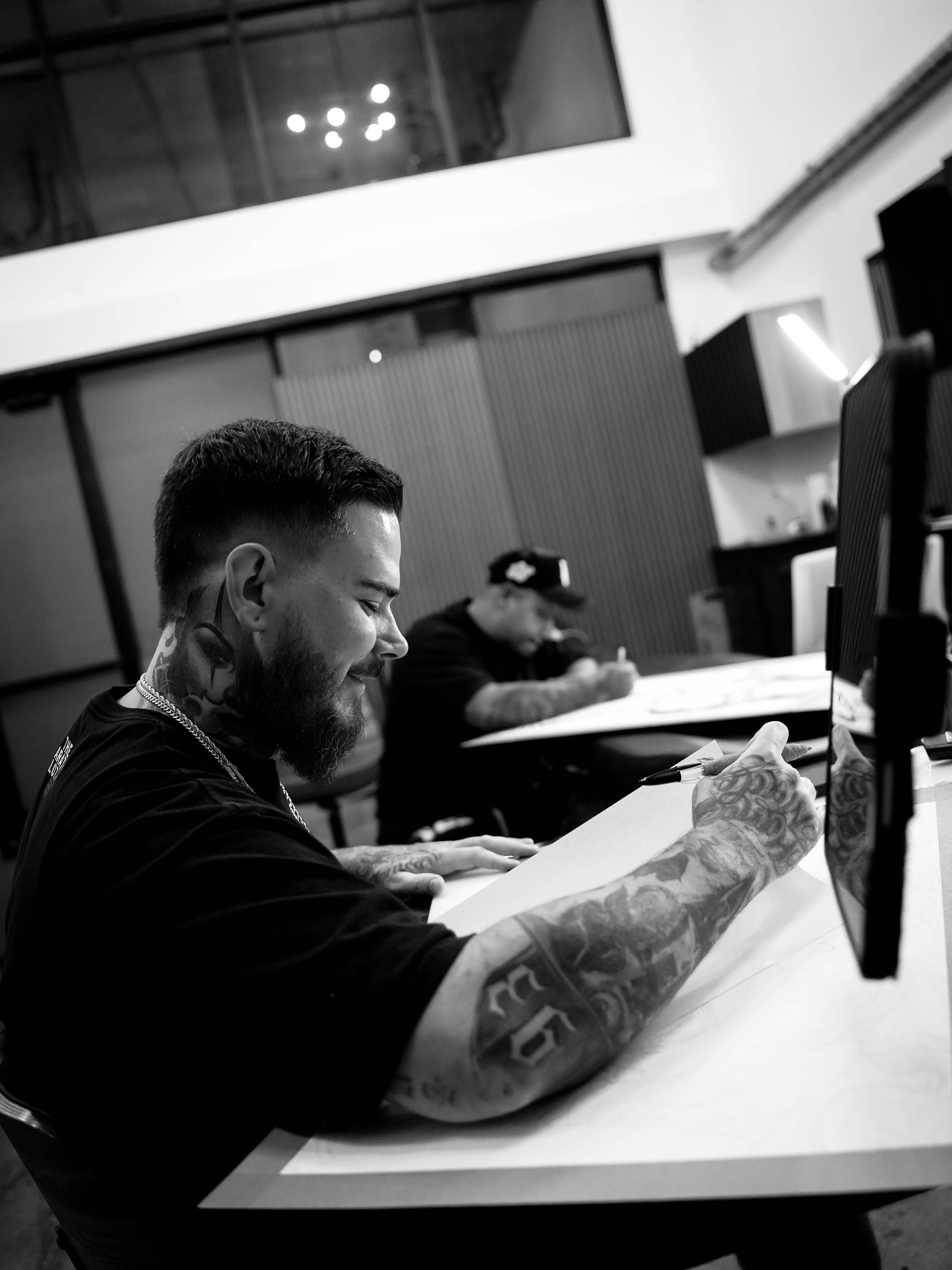 Bearded man black and grey tattoo on the upper arm by Travis