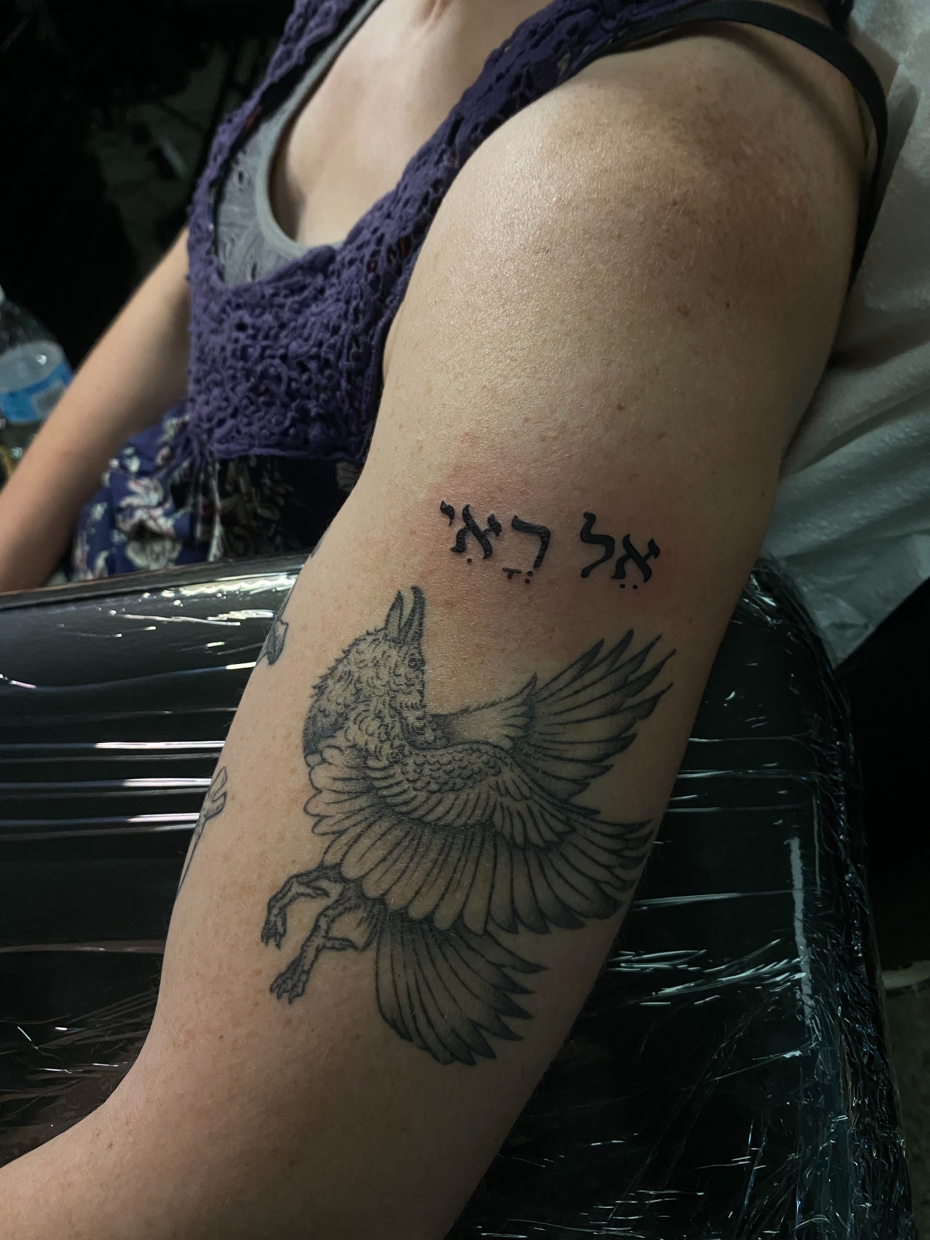 Crow and Hebrew text black and grey tattoo on the forearm by 𝕶𝖆𝖒 ~ 𝕿𝖆𝖙𝖙𝖔𝖔 𝕬𝖗𝖙𝖎𝖘𝖙