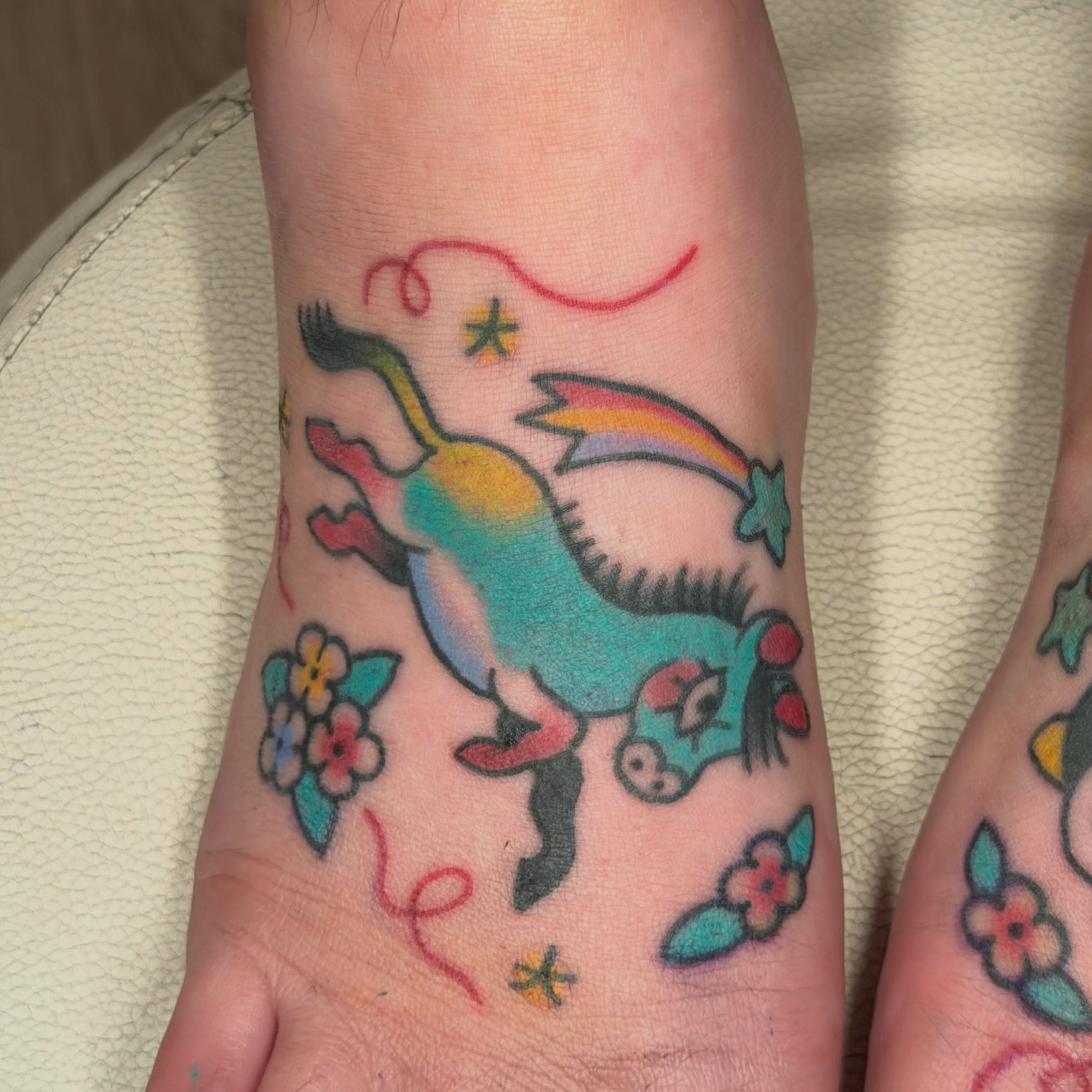 Unicorn and rainbow American traditional tattoo on the forearm by Gus Roach Graves