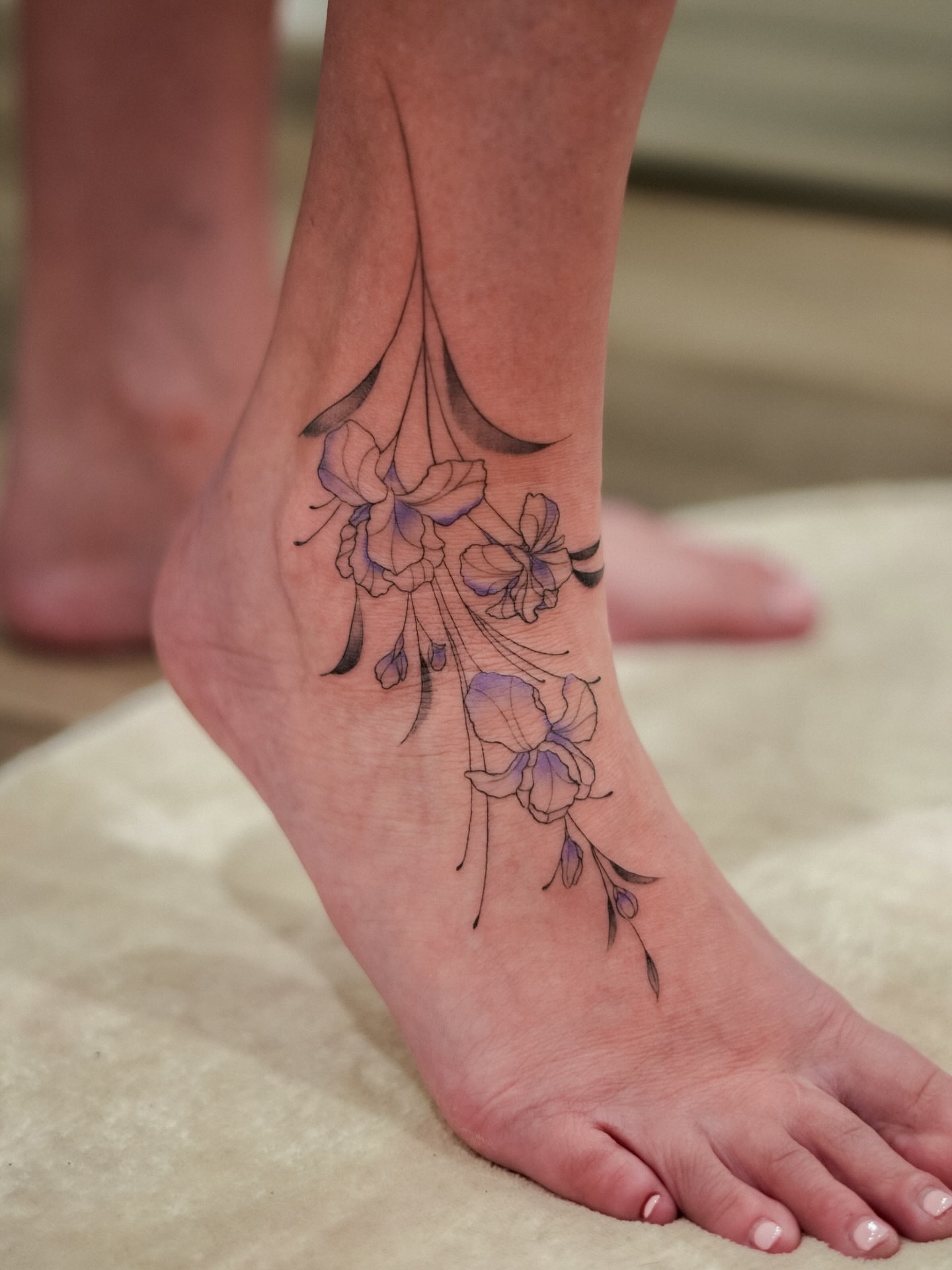 Flowers fine line tattoo on the foot by Adriano Bassalo