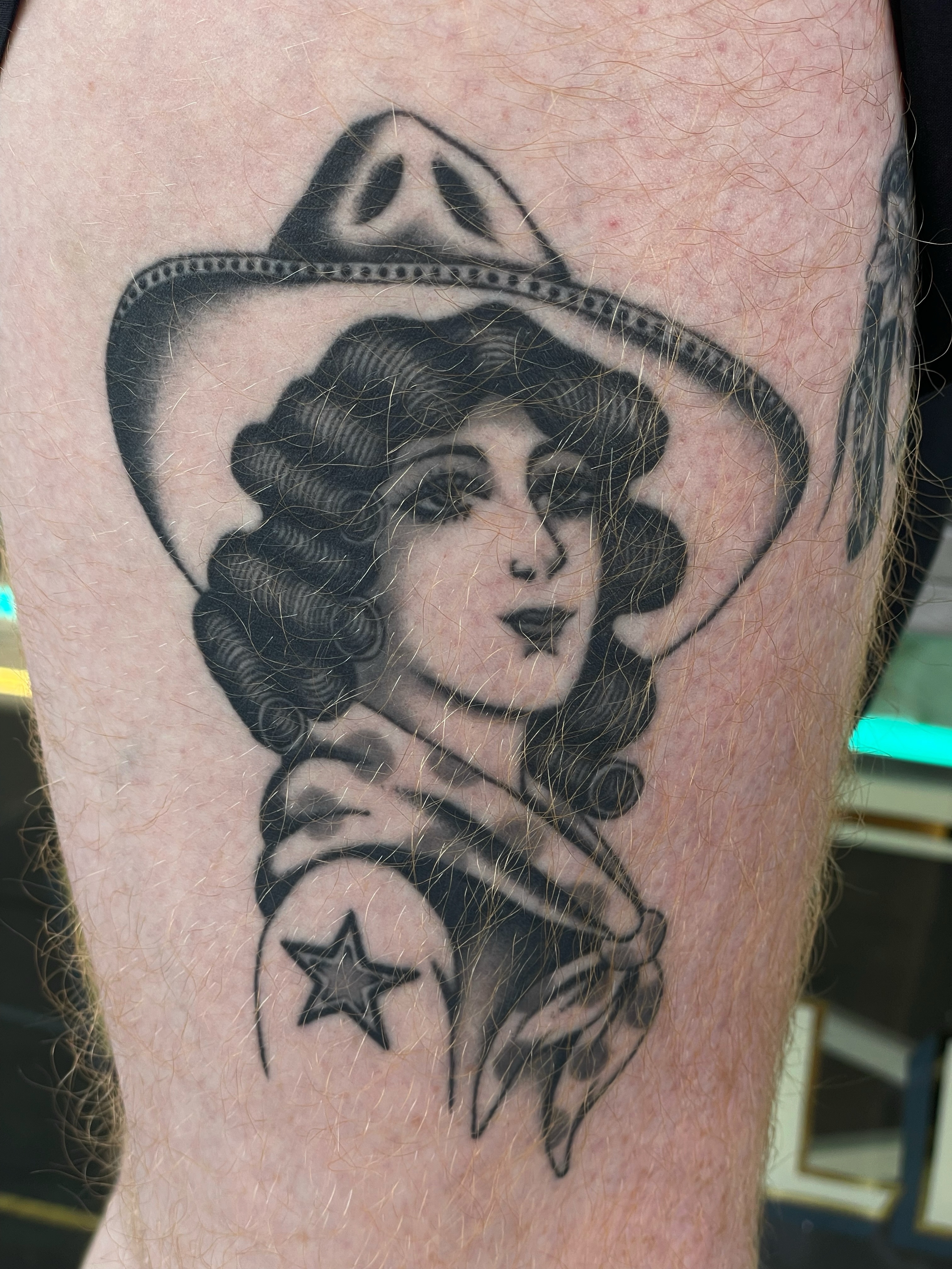 Cowgirl portrait realism tattoo on the thigh by Niko Mulhearn