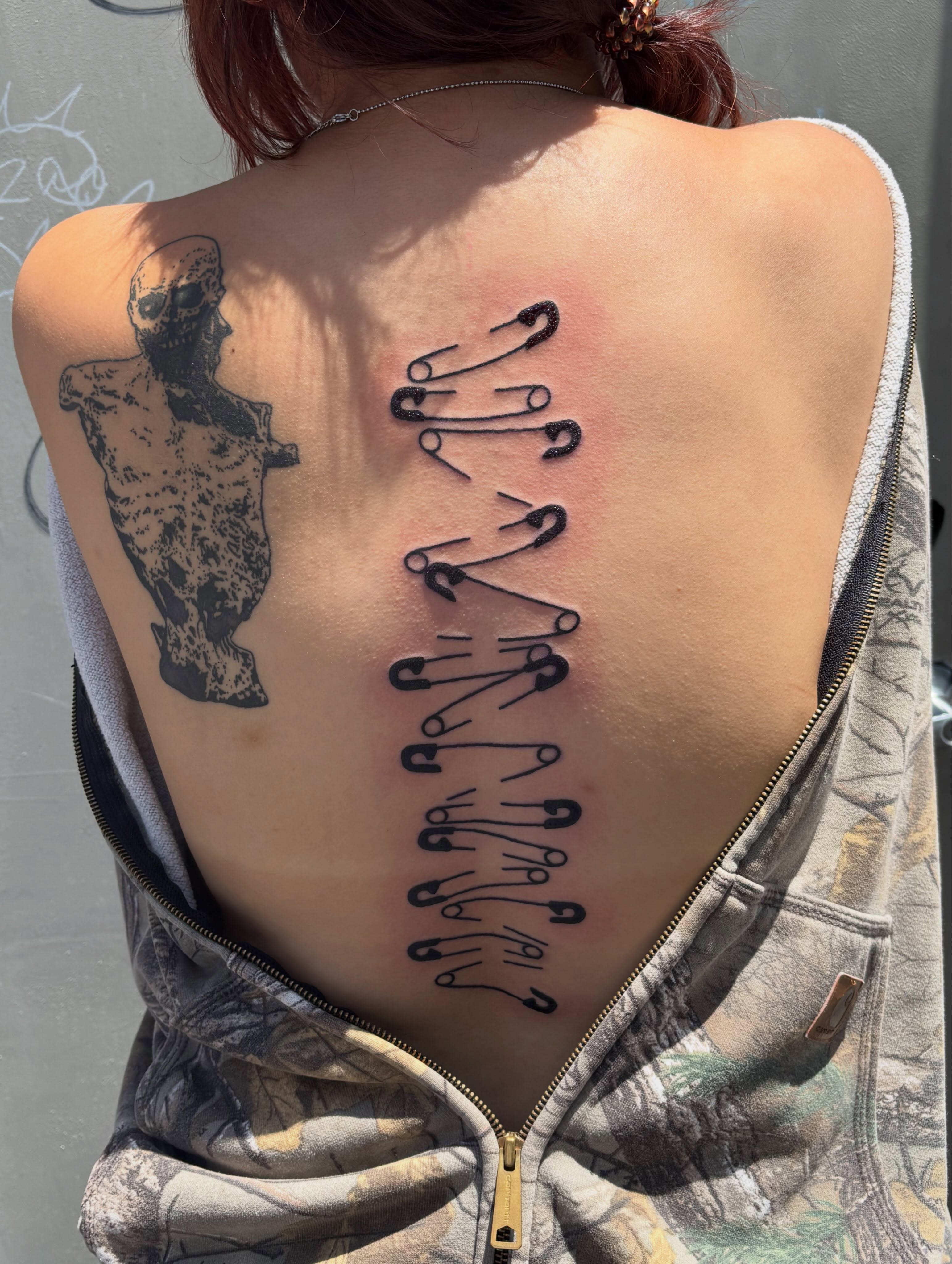 Safety pins black and grey tattoo on the back by Turner