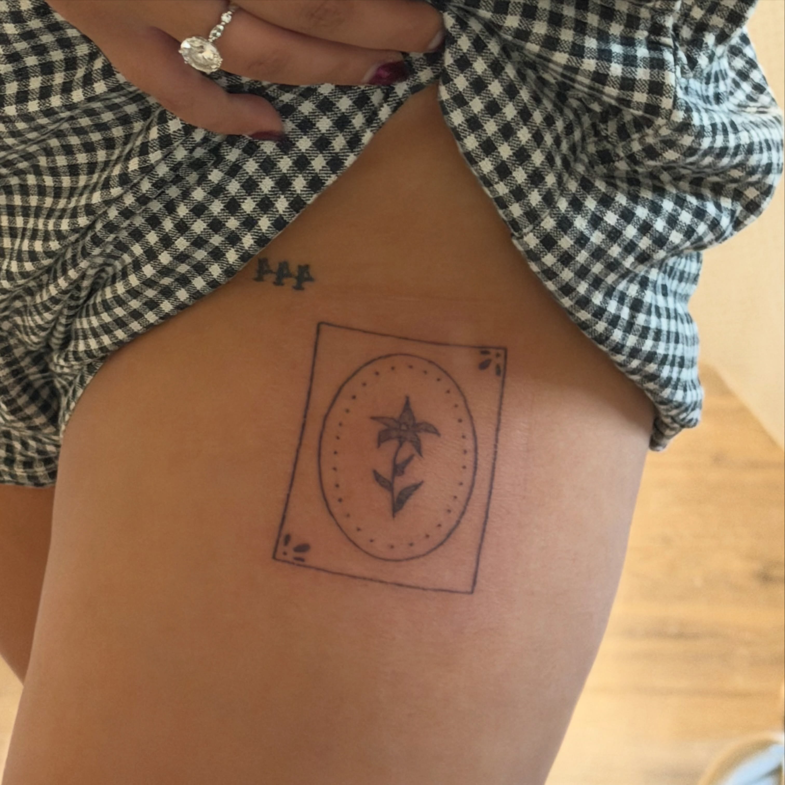 Flower in oval dotwork tattoo on the thigh by Alyssa
