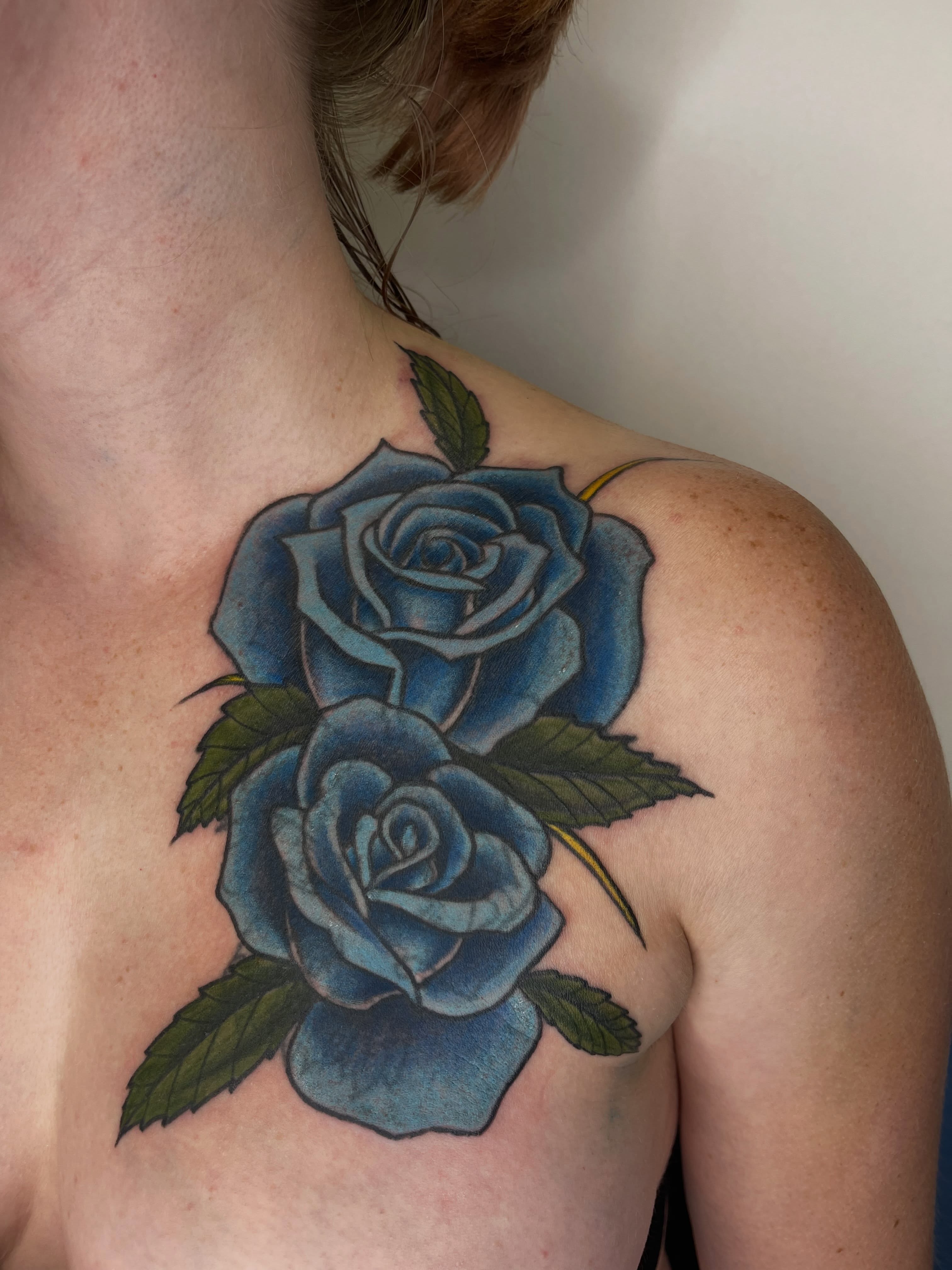 Blue roses realism tattoo on the chest by Allison Gallagher