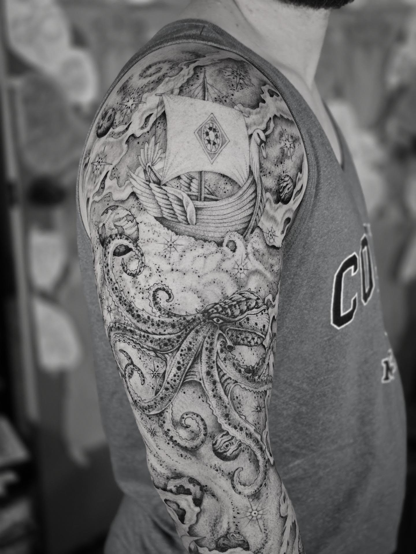 Ship and sea dotwork tattoo on the upper arm by Aaron Dor