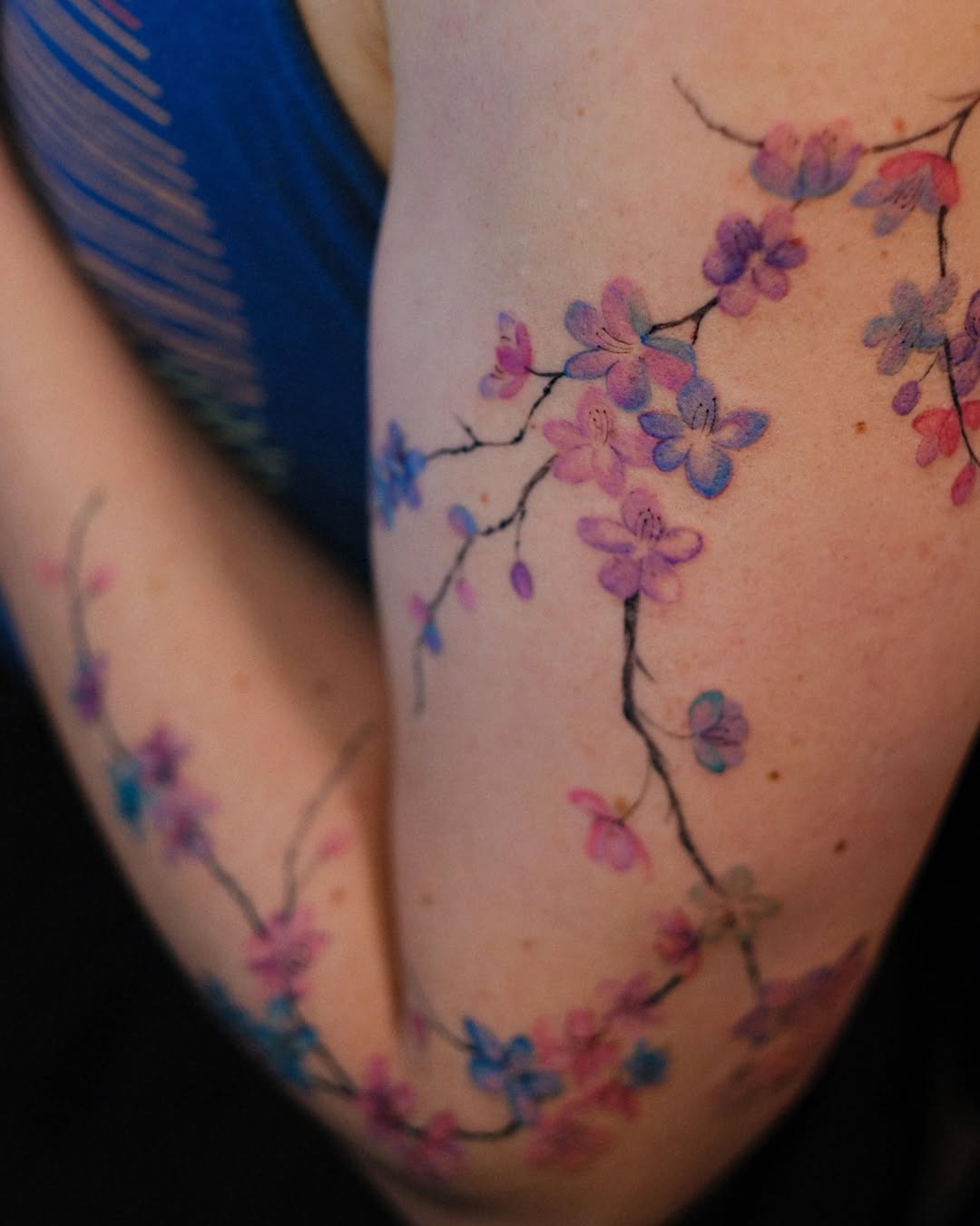 Cherry blossoms watercolor tattoo on the thigh by Temple Adorned Tattoo