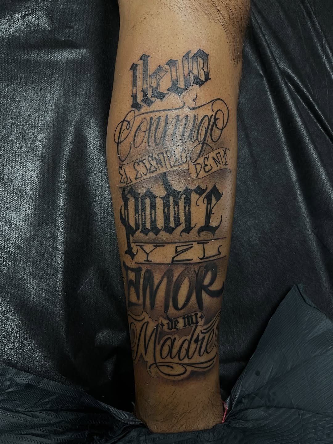 Text and script Chicano tattoo on the forearm by Chris Torres