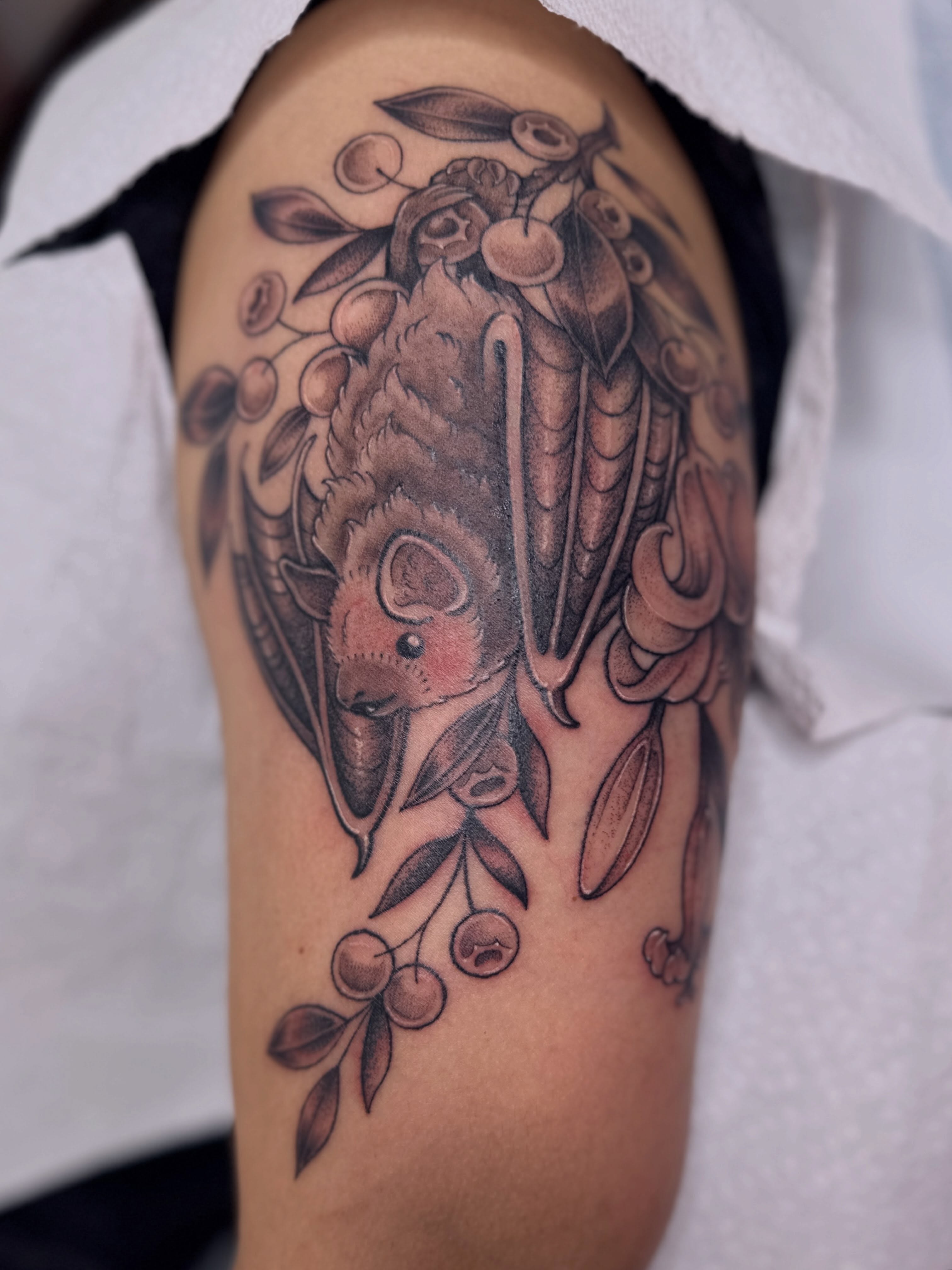 Bat and cherries American traditional tattoo on the shoulder by Dani Di Pietrantonio