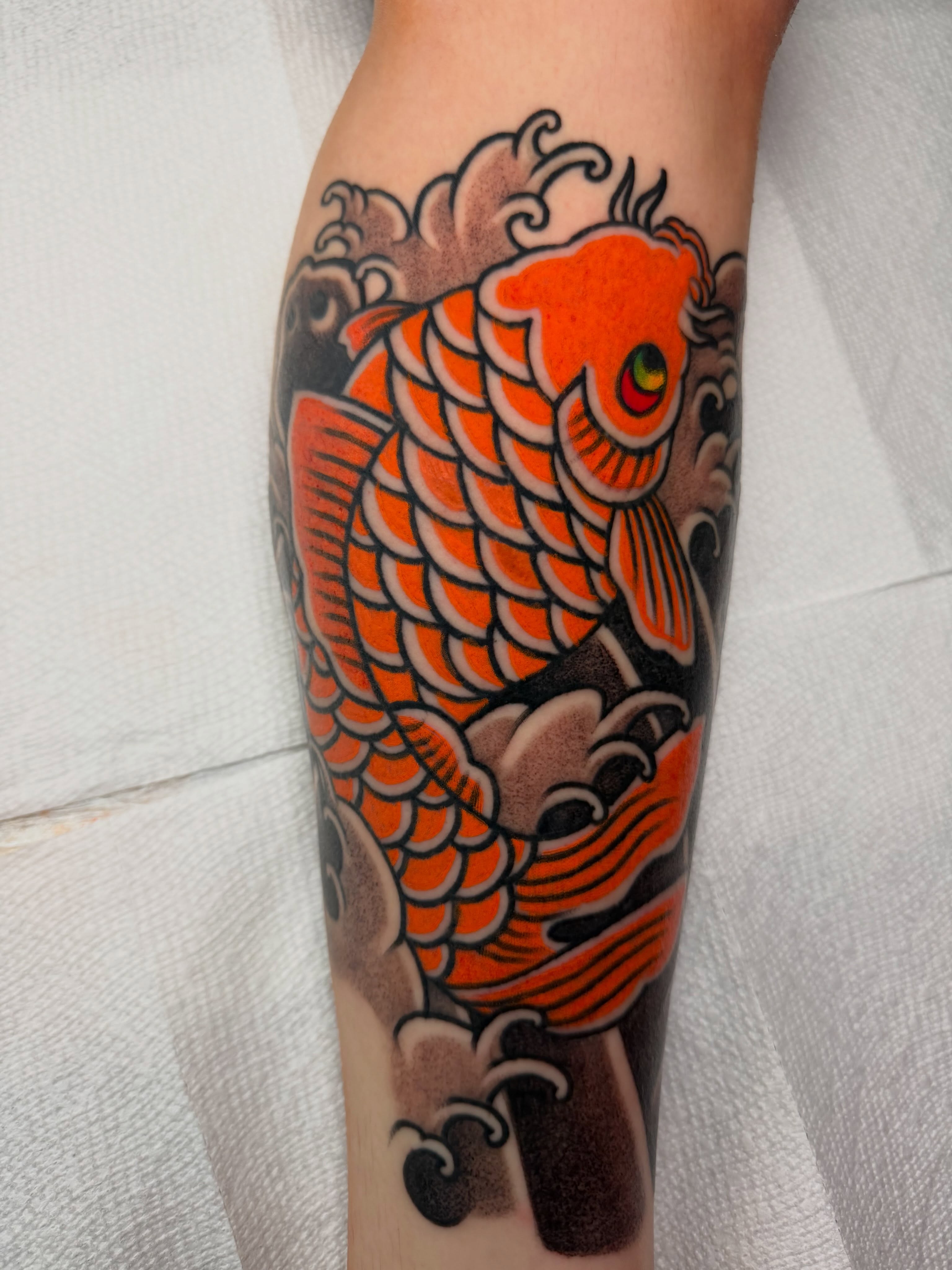 Koi fish American traditional tattoo on the forearm by Don Lee