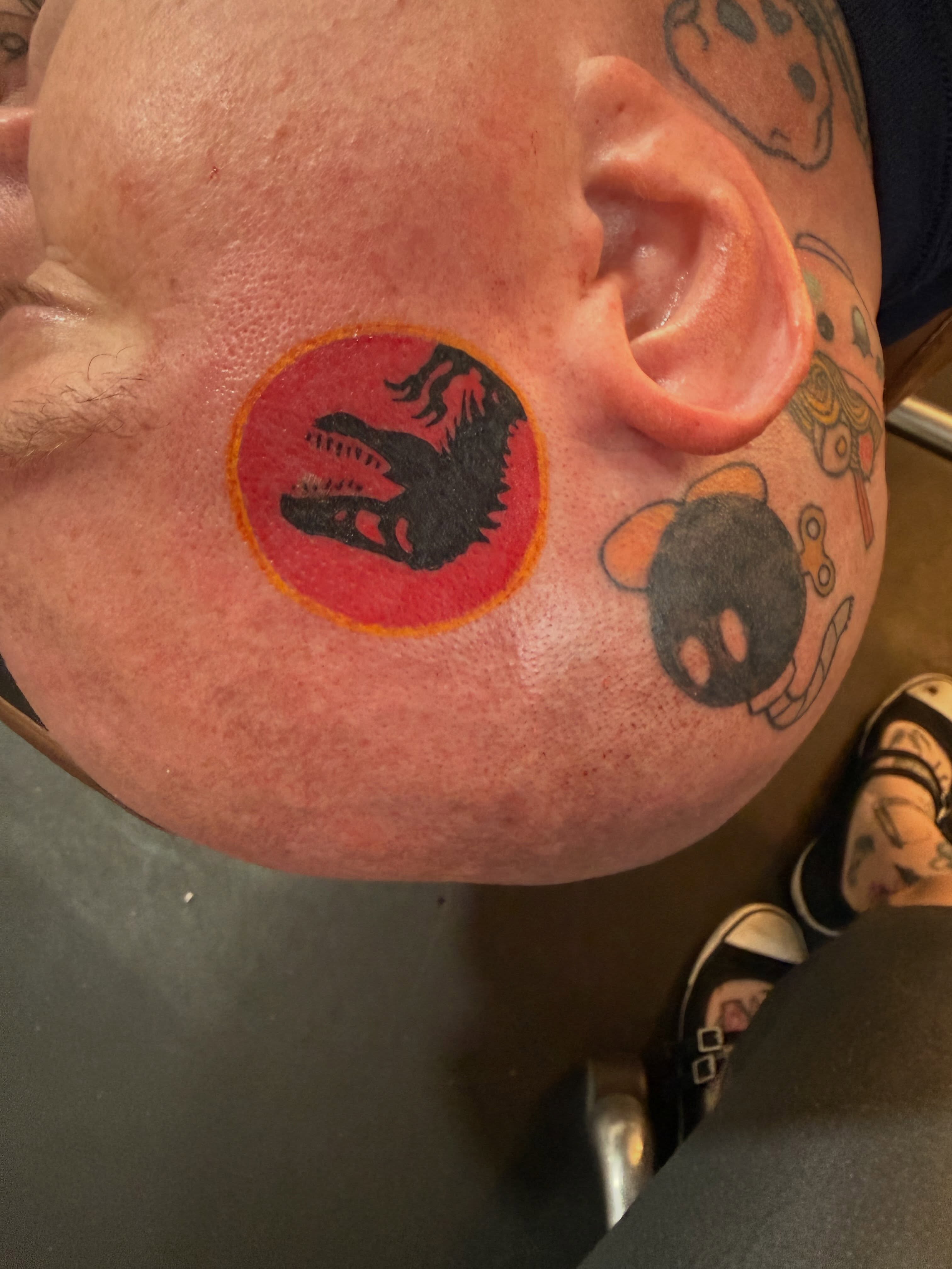Dinosaur American traditional tattoo on the head by Brandie Caroline, Somers Point, New Jersey