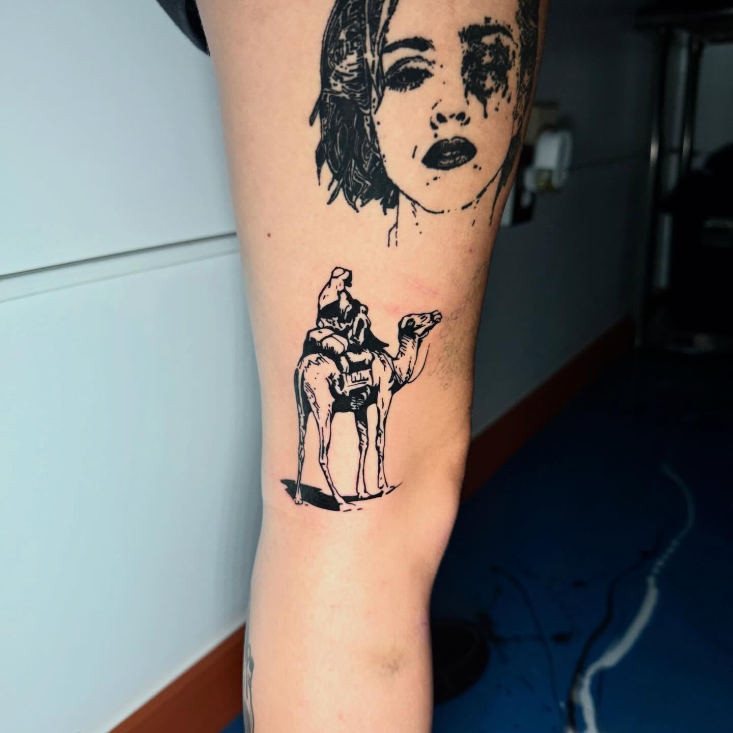 Woman riding camel black and grey tattoo on the forearm by Lip™