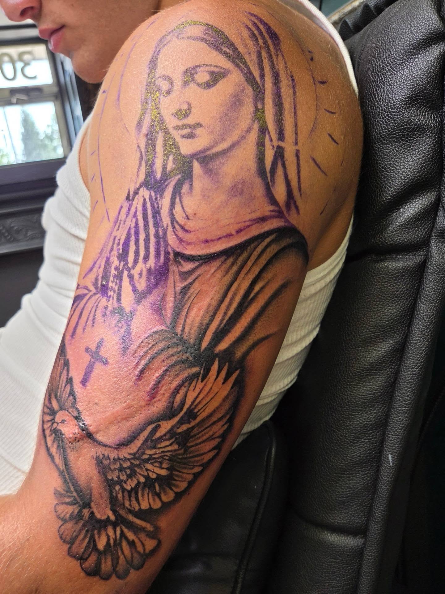 Religious angel realism tattoo on the upper arm by Maya Neideck