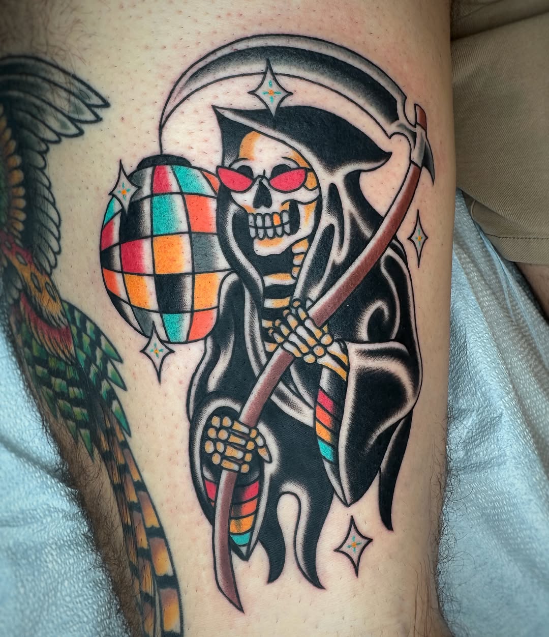Reaper with disco ball American traditional tattoo on the thigh by Cori James Tattoo Artist