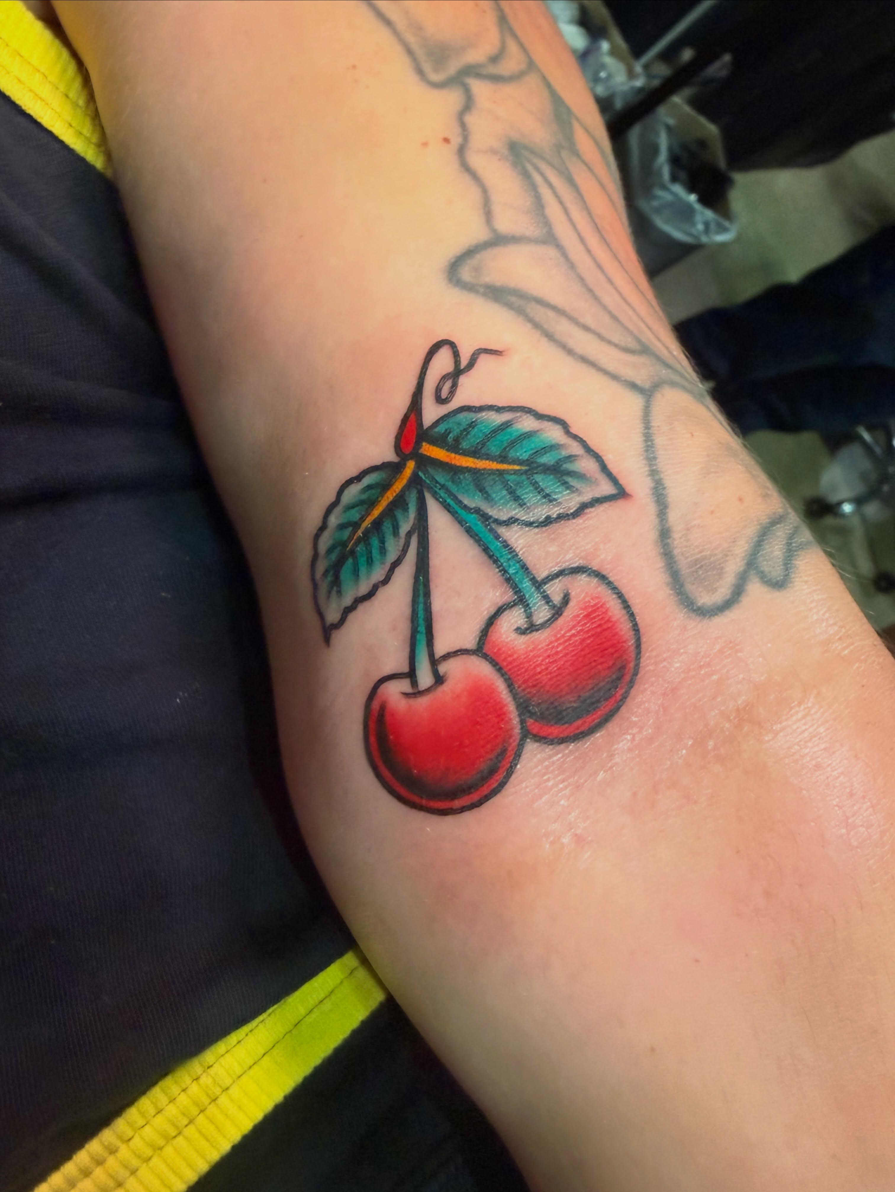 Cherries American traditional tattoo on the forearm by Macy Bird
