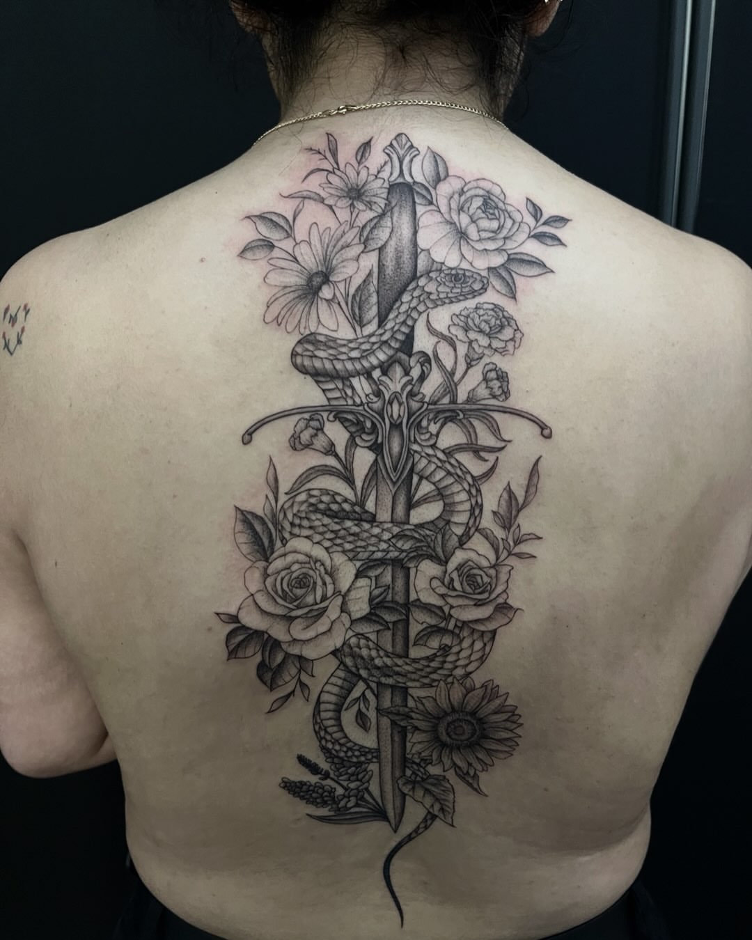 Snake and flowers realism tattoo on the back by Iraymi Beltran
