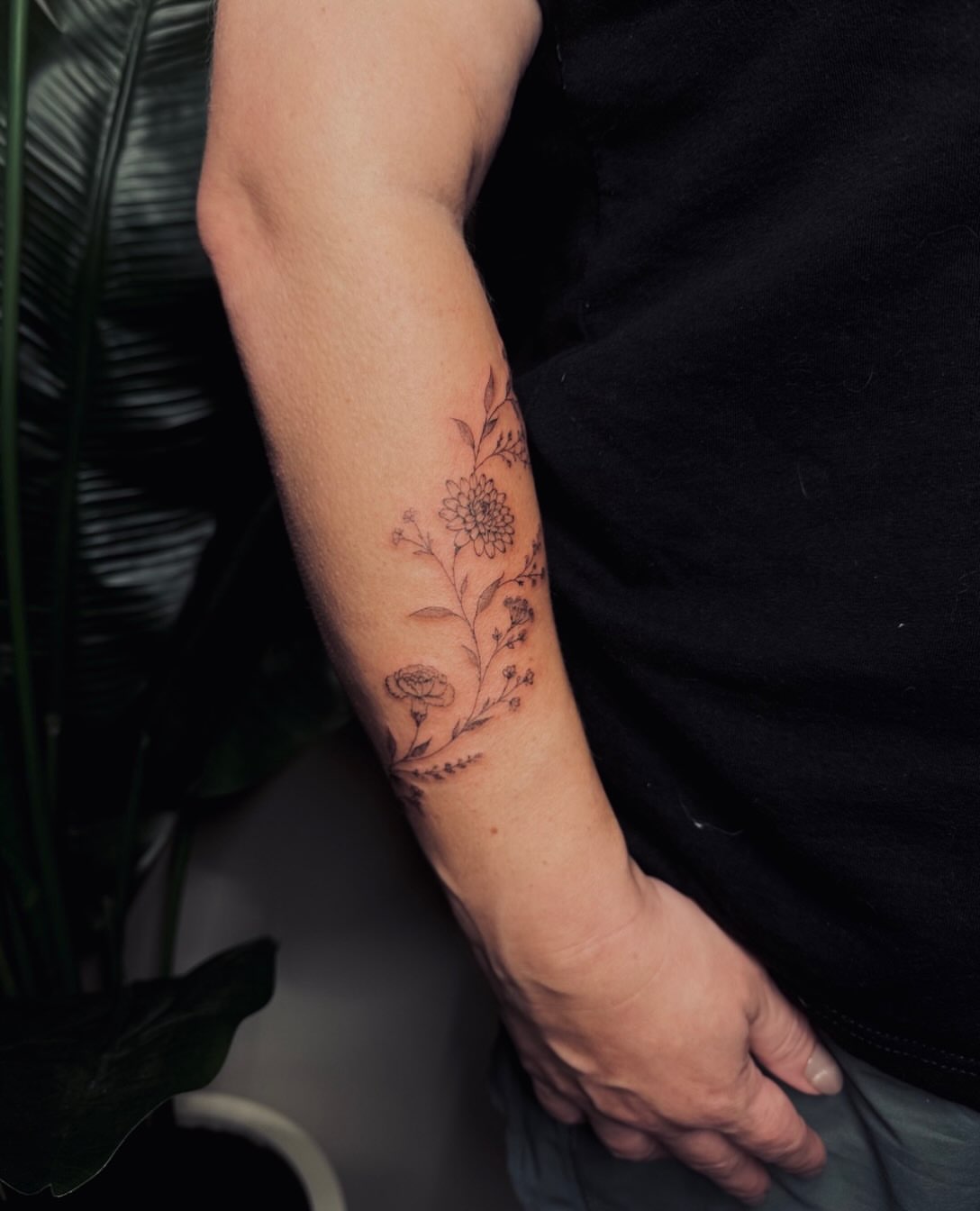 Floral arrangement black and grey tattoo on the forearm by Ashley Pilgreen