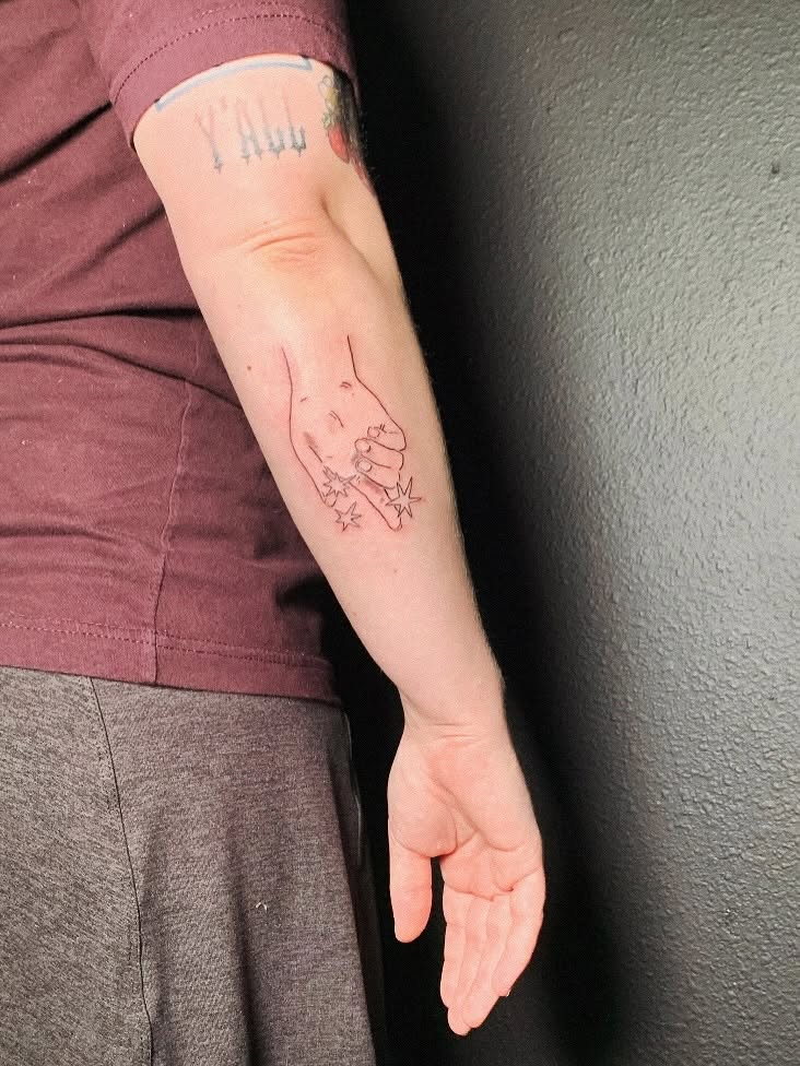 Hand with stars fine line tattoo on the forearm by charles