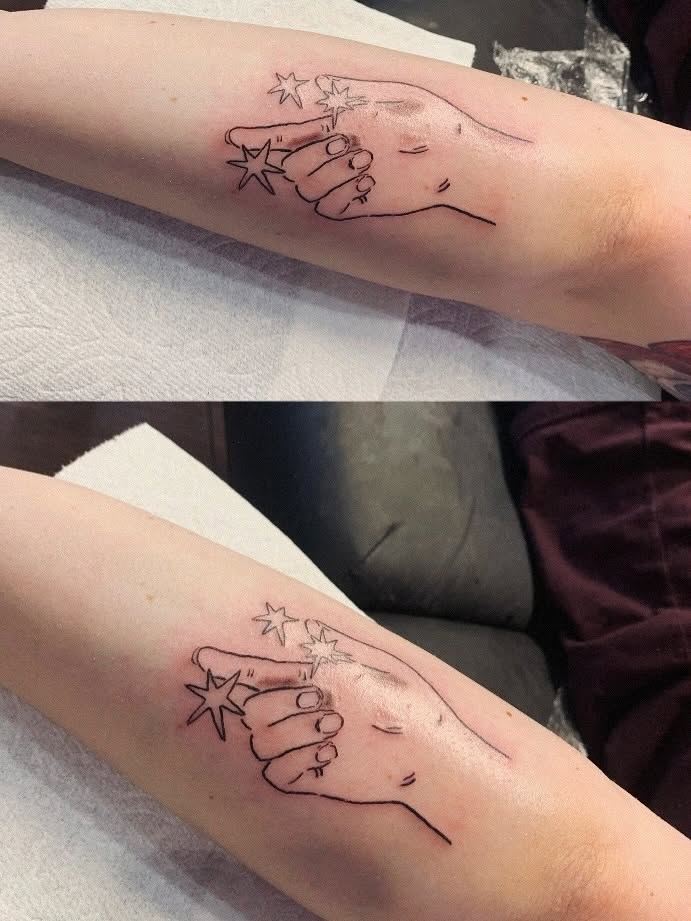 Hand with stars fine line tattoo on the forearm by charles