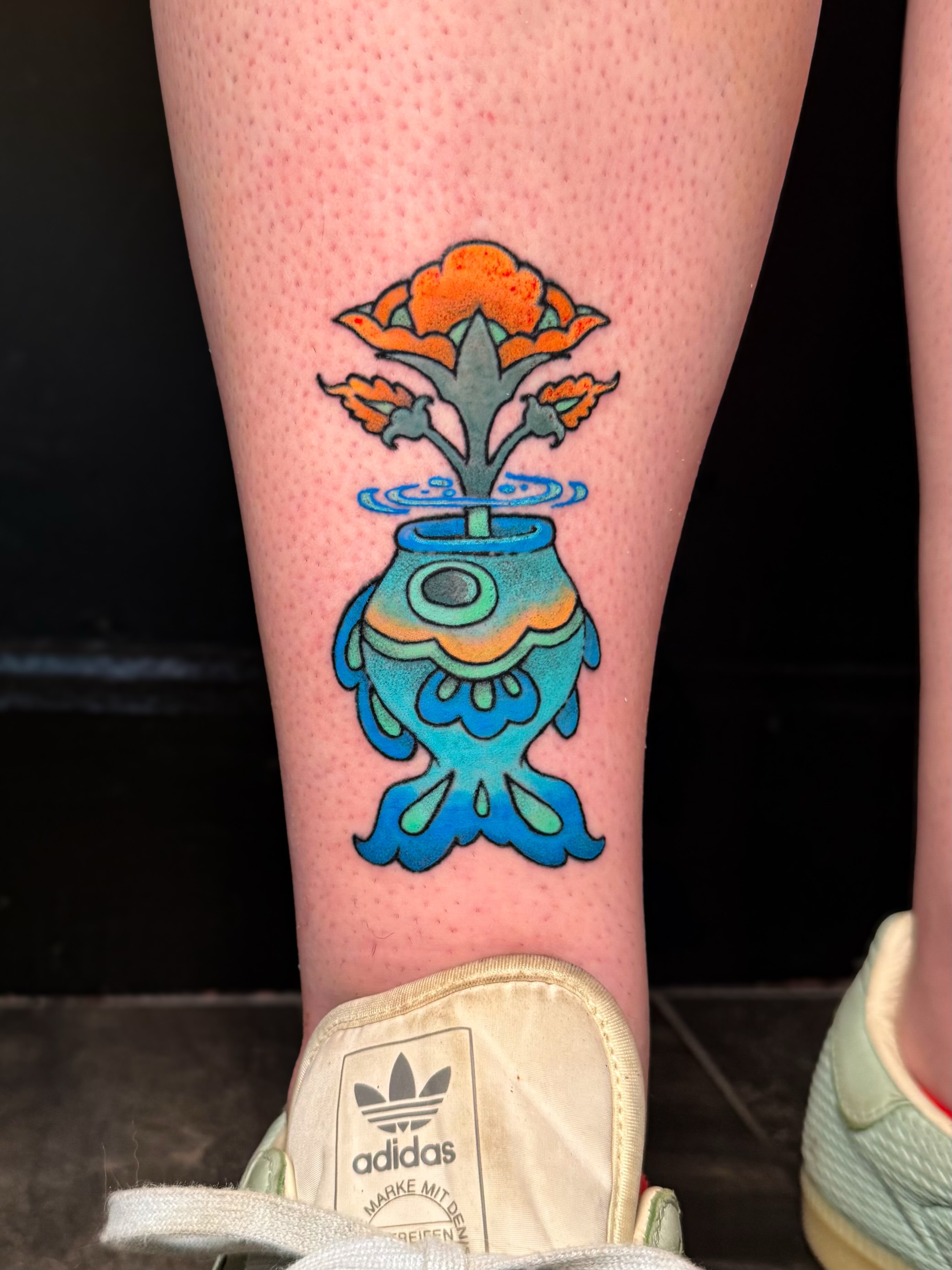 Fish vase with flower new school tattoo on the calf by Ivy-Jade Edwards, Memphis, Tennessee