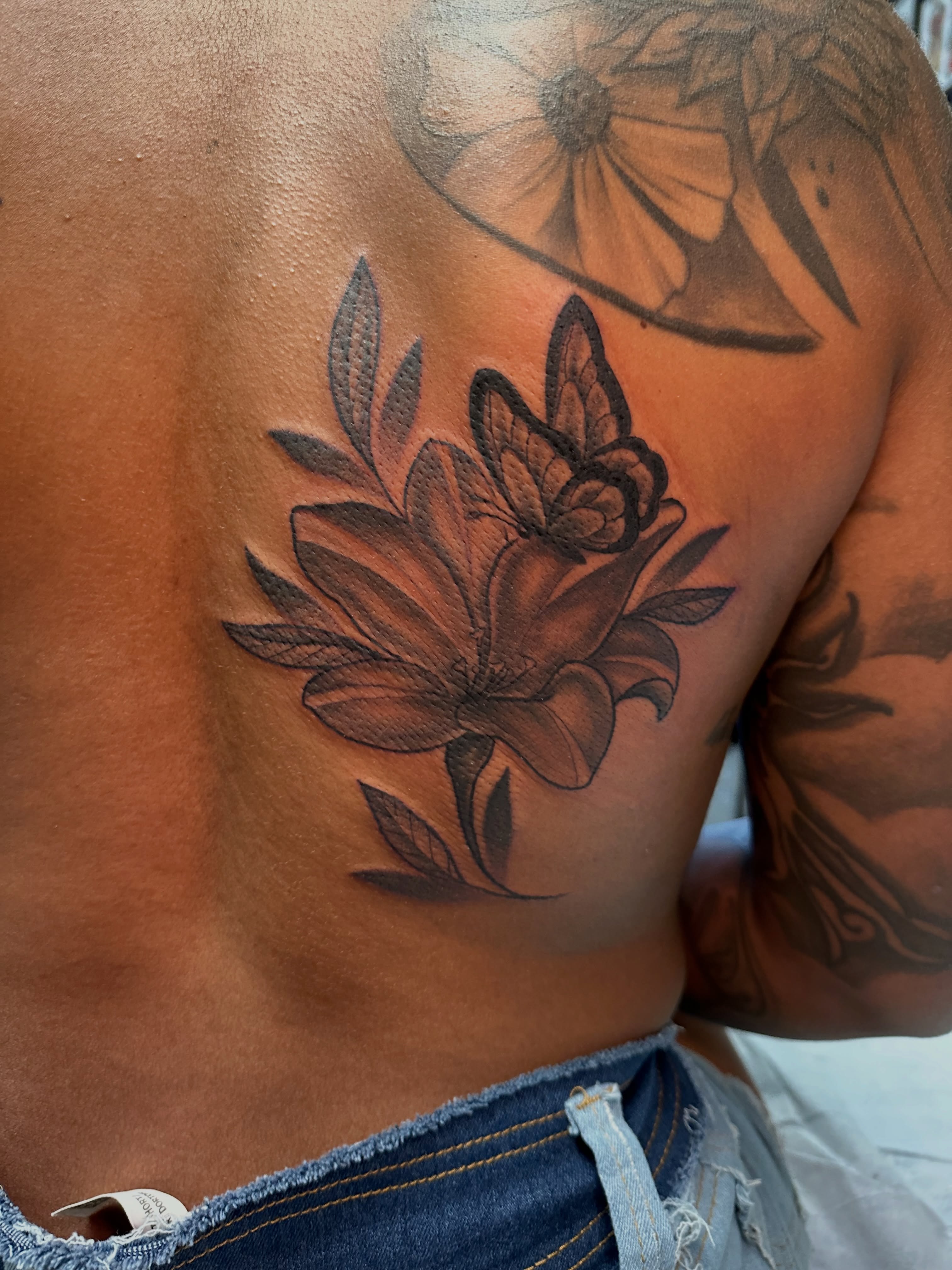 Lotus flower black and grey tattoo on the back by Mia Layne 🤎