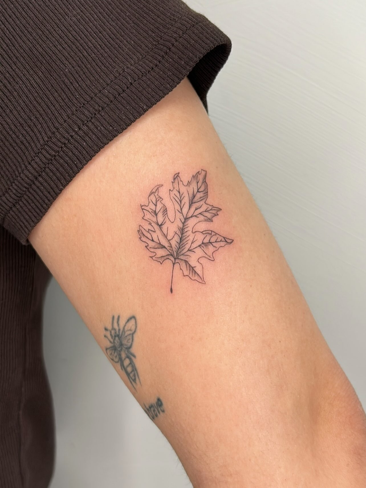 Maple leaf black and grey tattoo on the forearm by Harmony