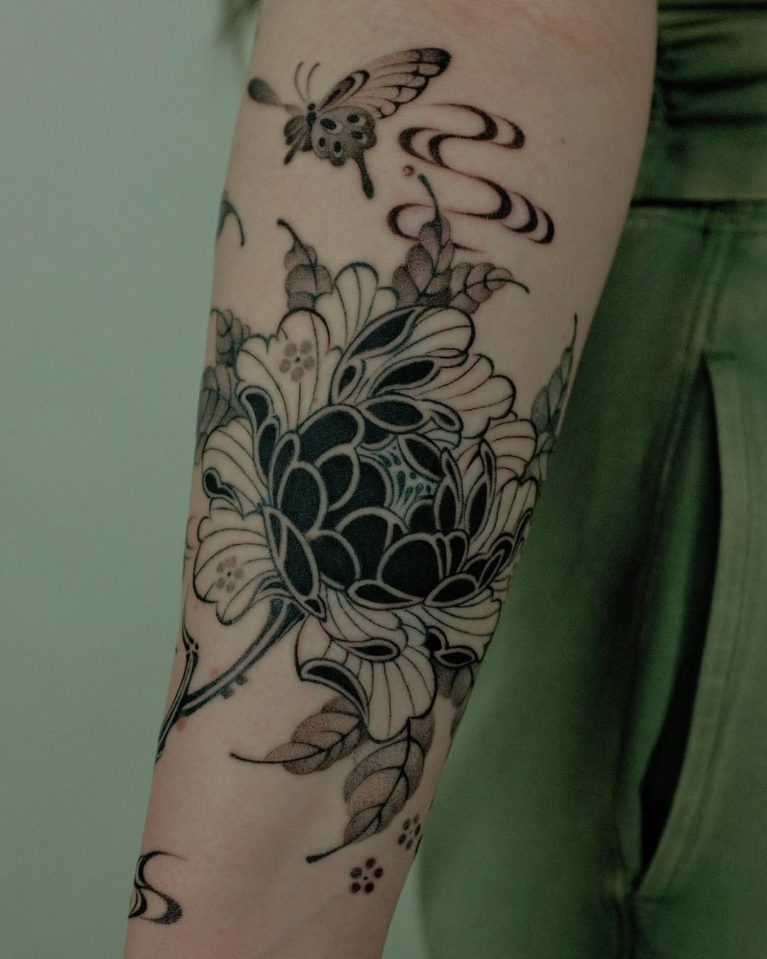 Flower and butterfly black and grey tattoo on the forearm by Xiao Lun