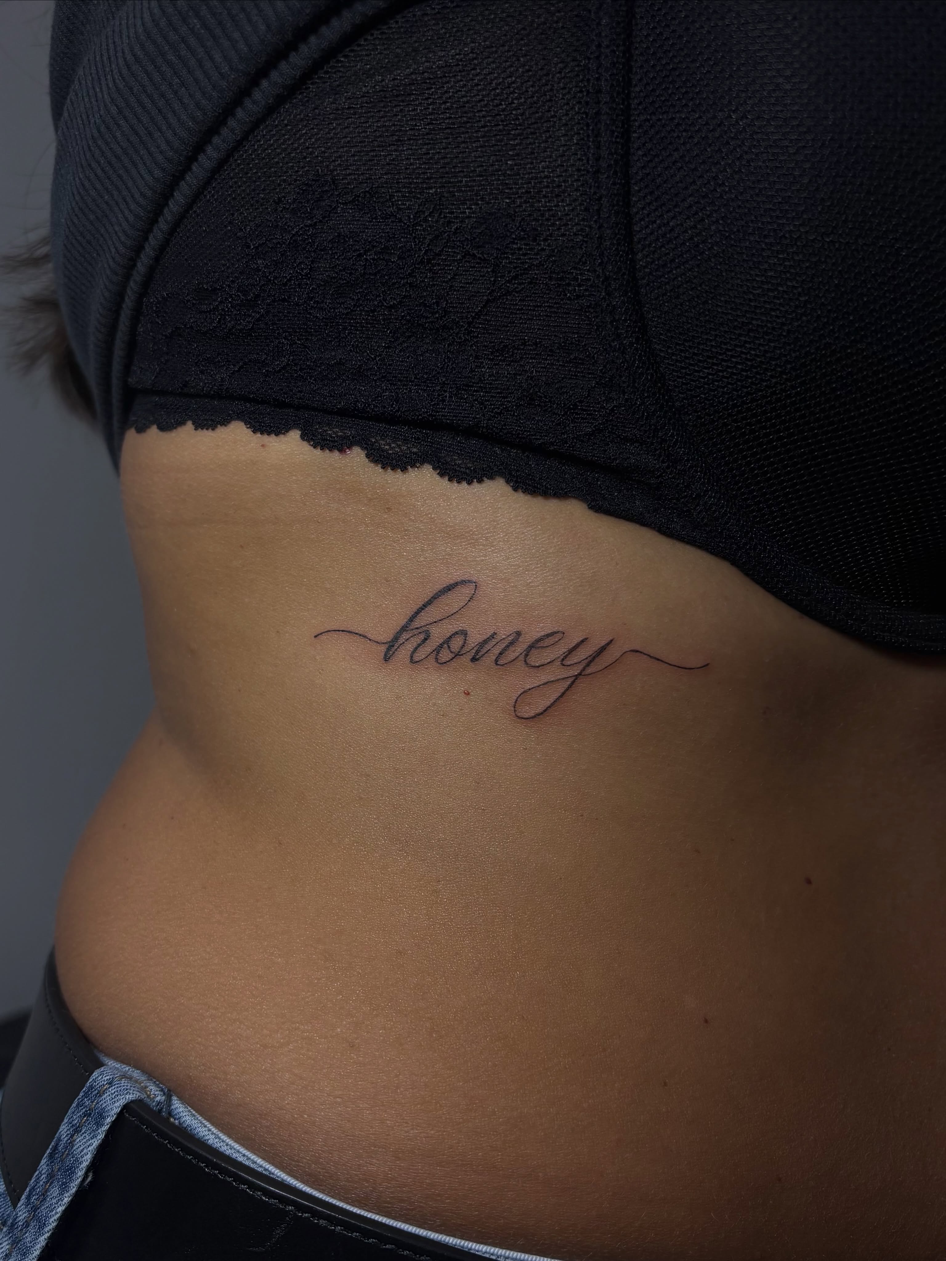 Honey lettering script tattoo on the ribs by Valentina