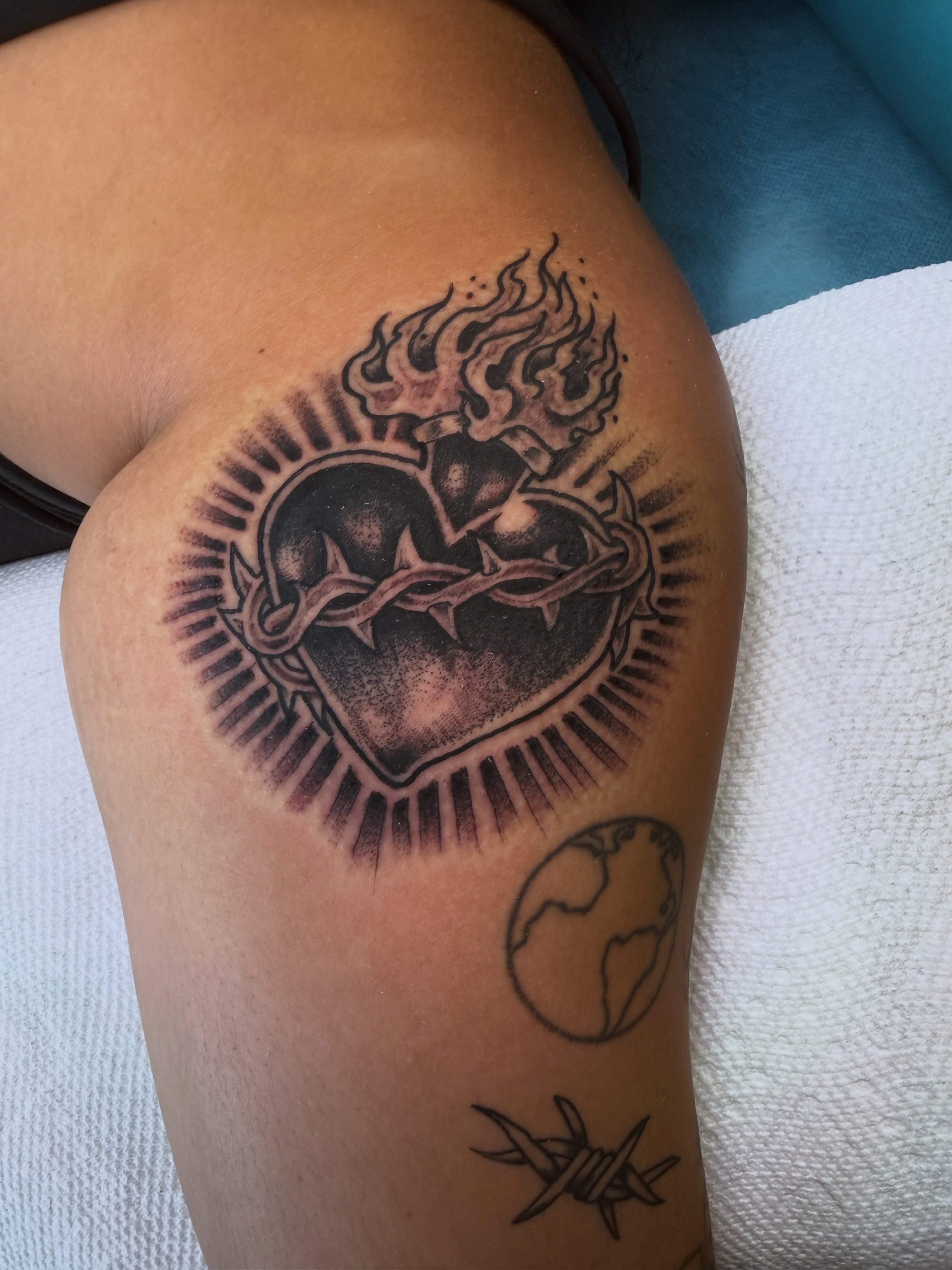 Heart with crown of thorns black and grey tattoo on the thigh by Ramón Silva
