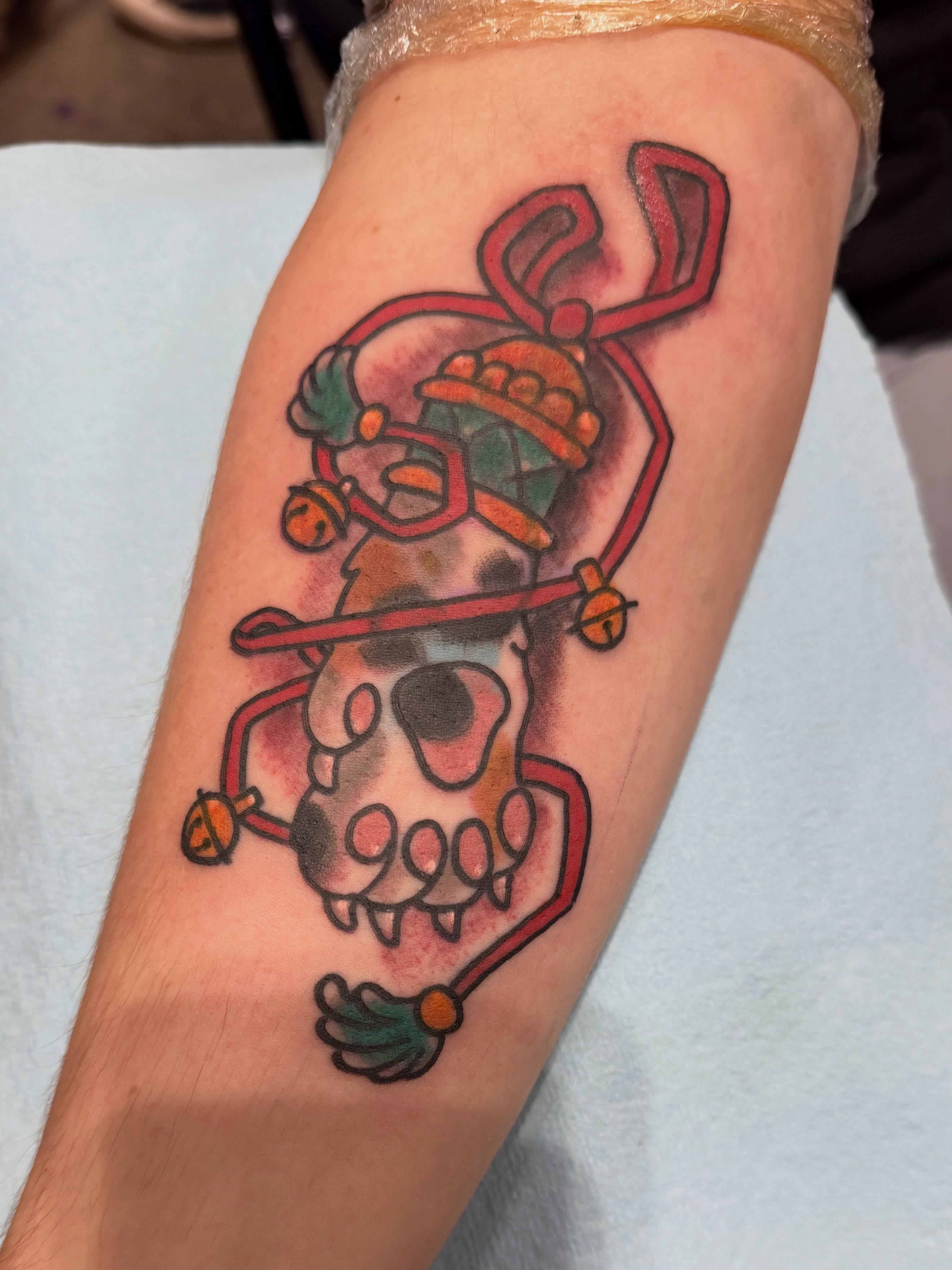 Skull with bells American traditional tattoo on the forearm by Sean Wilcox, Des Moines, Iowa